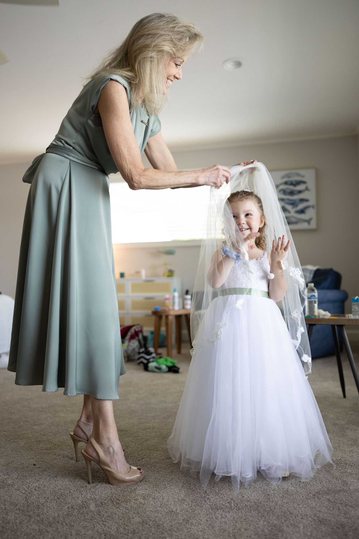 A touching moment during wedding preparations with a flower girl in a white dress.