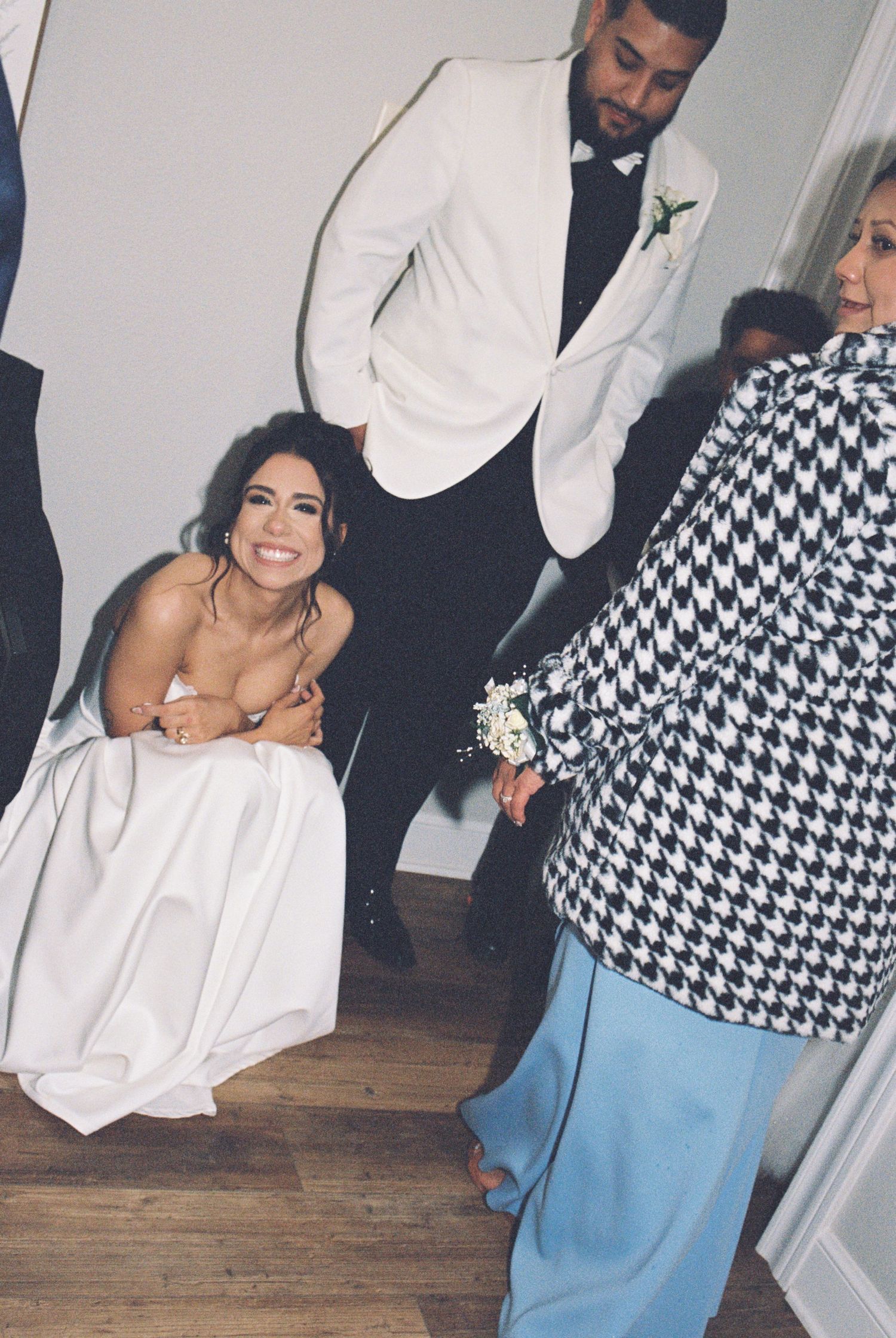 Wedding celebration candid with guests in formal attire at an indoor venue.