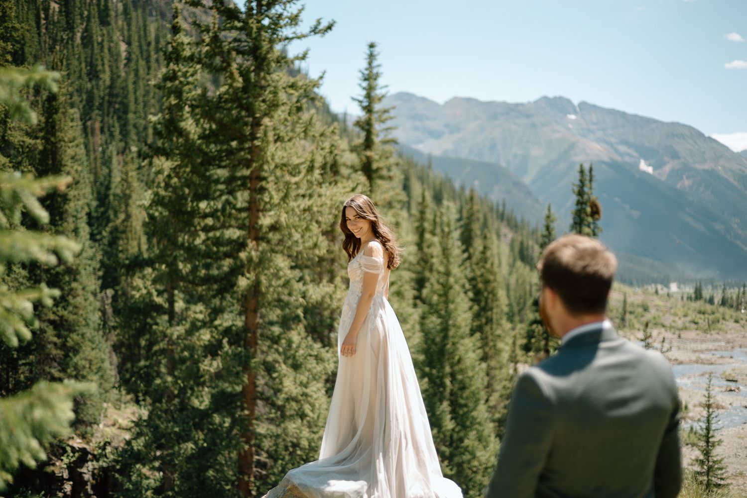 Wedding photoshoot with stunning mountain scenery and evergreen trees.