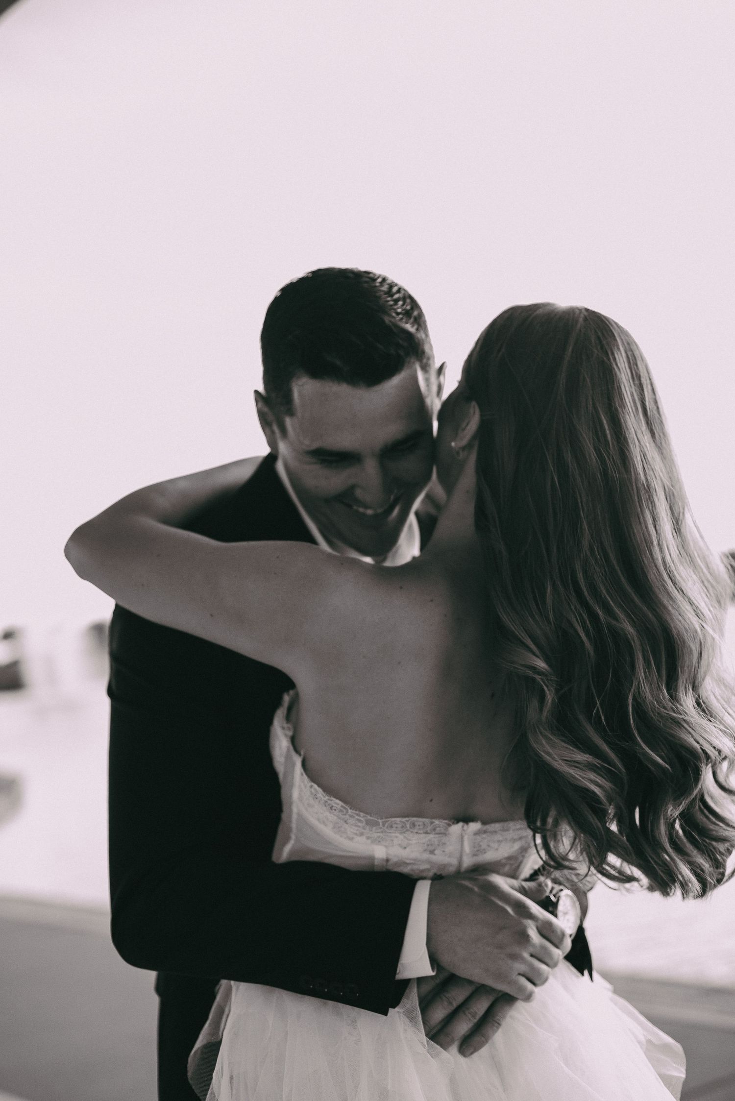 An intimate black and white portrait capturing a romantic embrace during a special moment.
