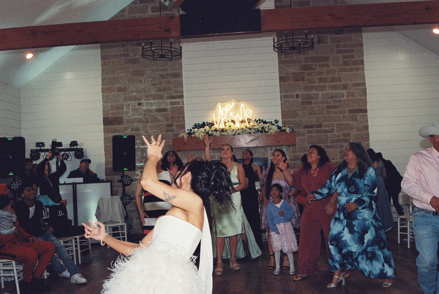 A person in a wedding dress throws their bouquet during the traditional reception toss.