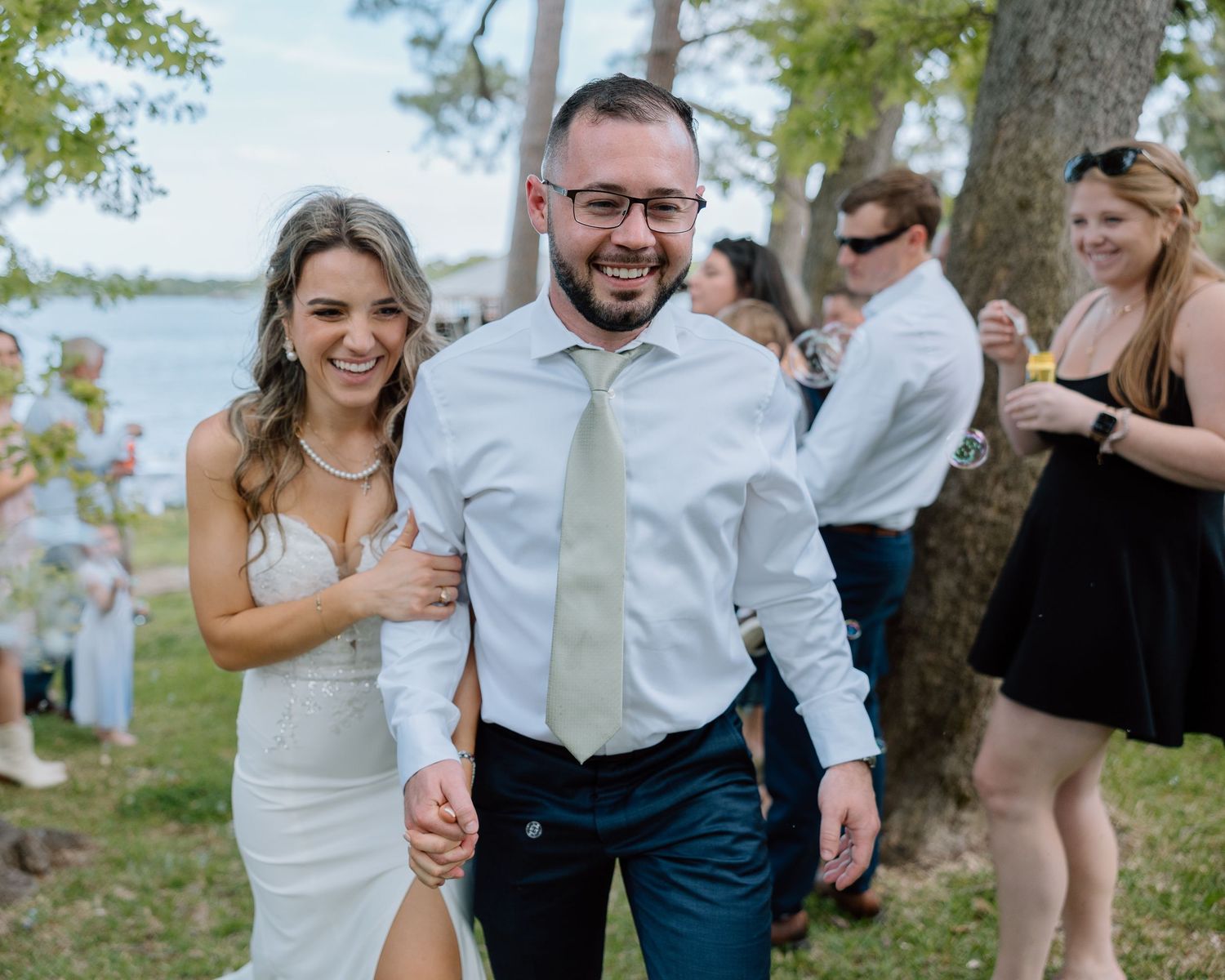 A happy couple walking together during their outdoor waterfront celebration.