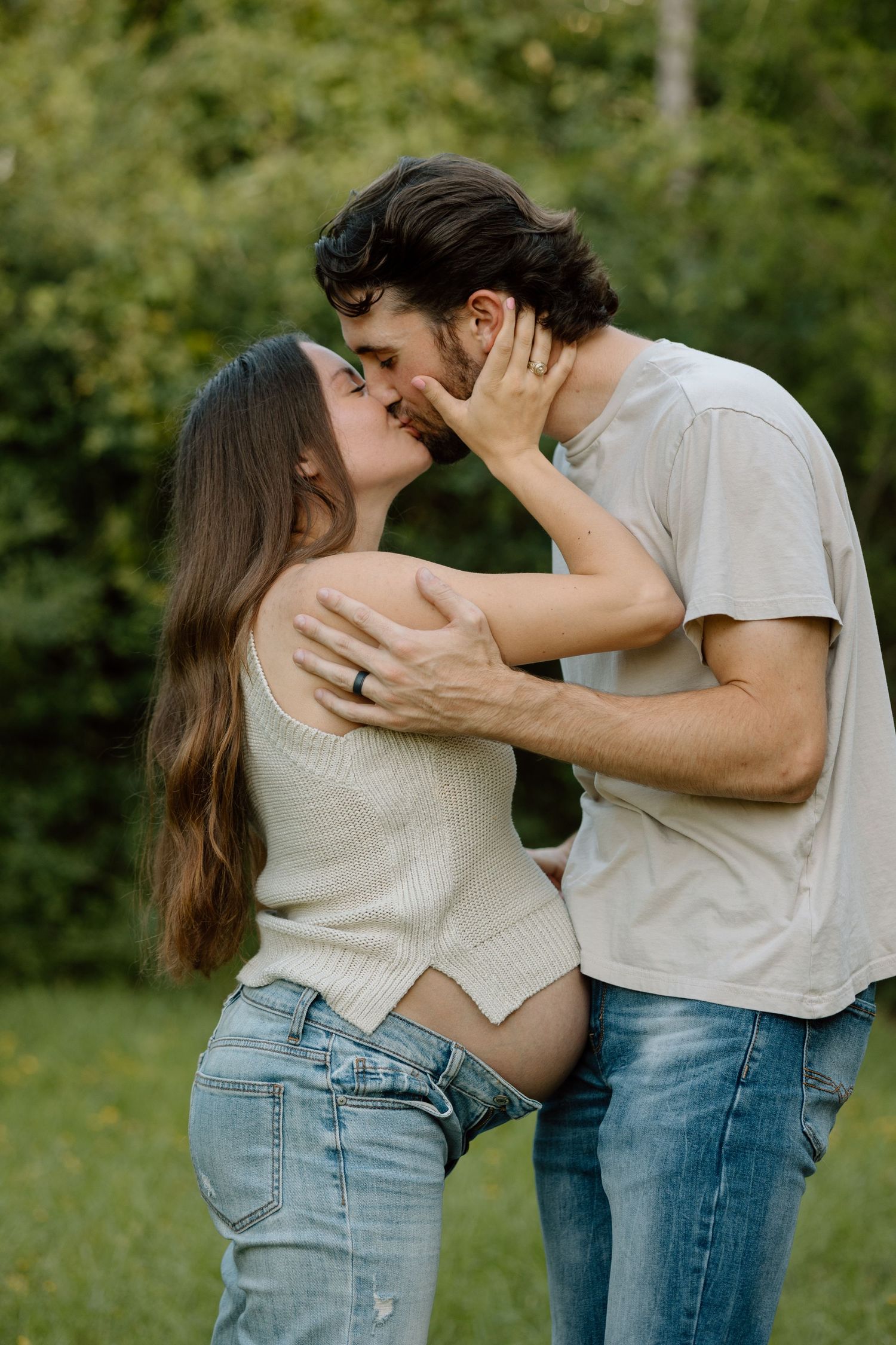 A romantic moment captured between two people sharing an intimate kiss outdoors.