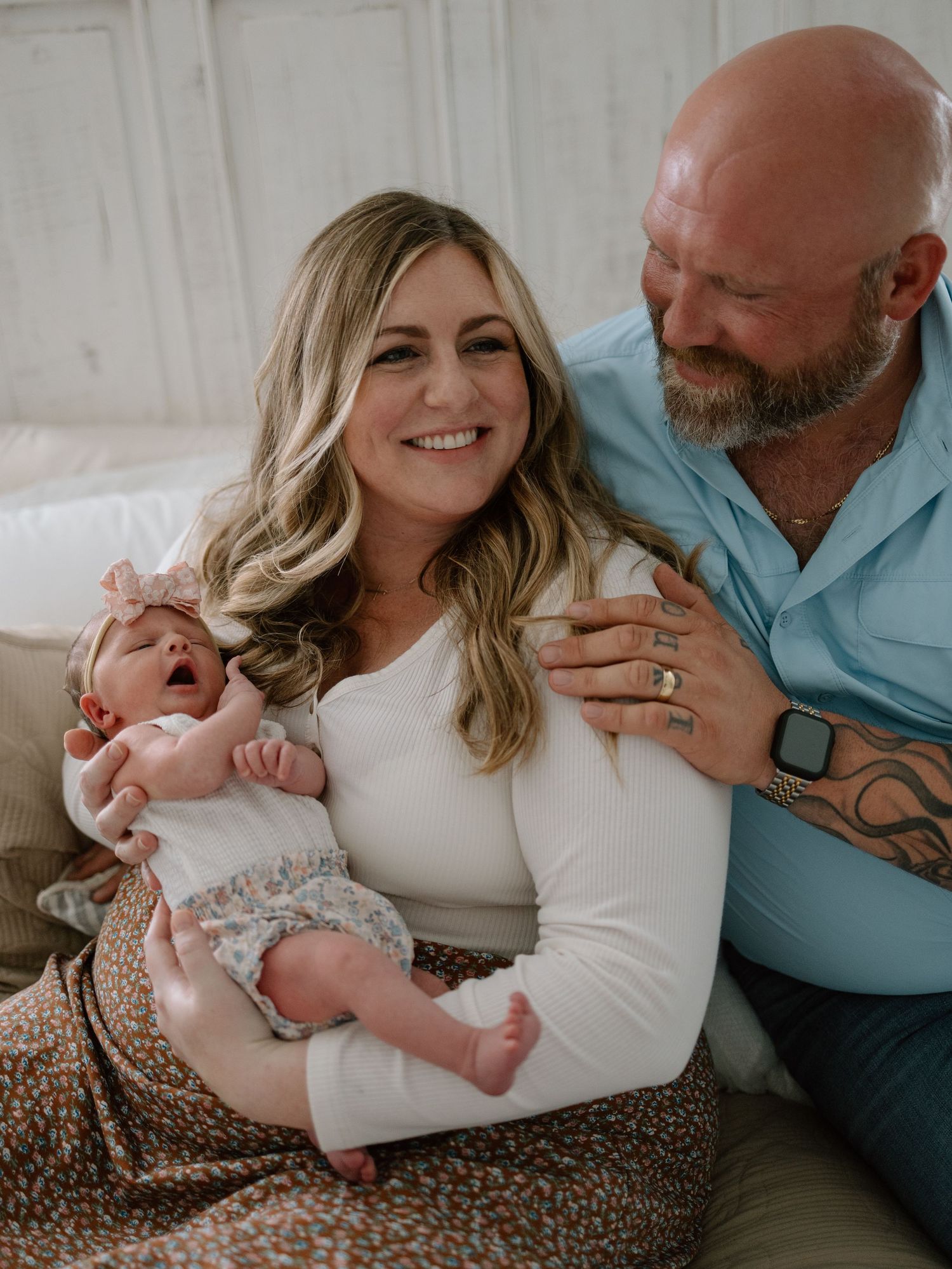 A loving family moment captured with their newborn baby in a cozy indoor setting showing warmth and connection.