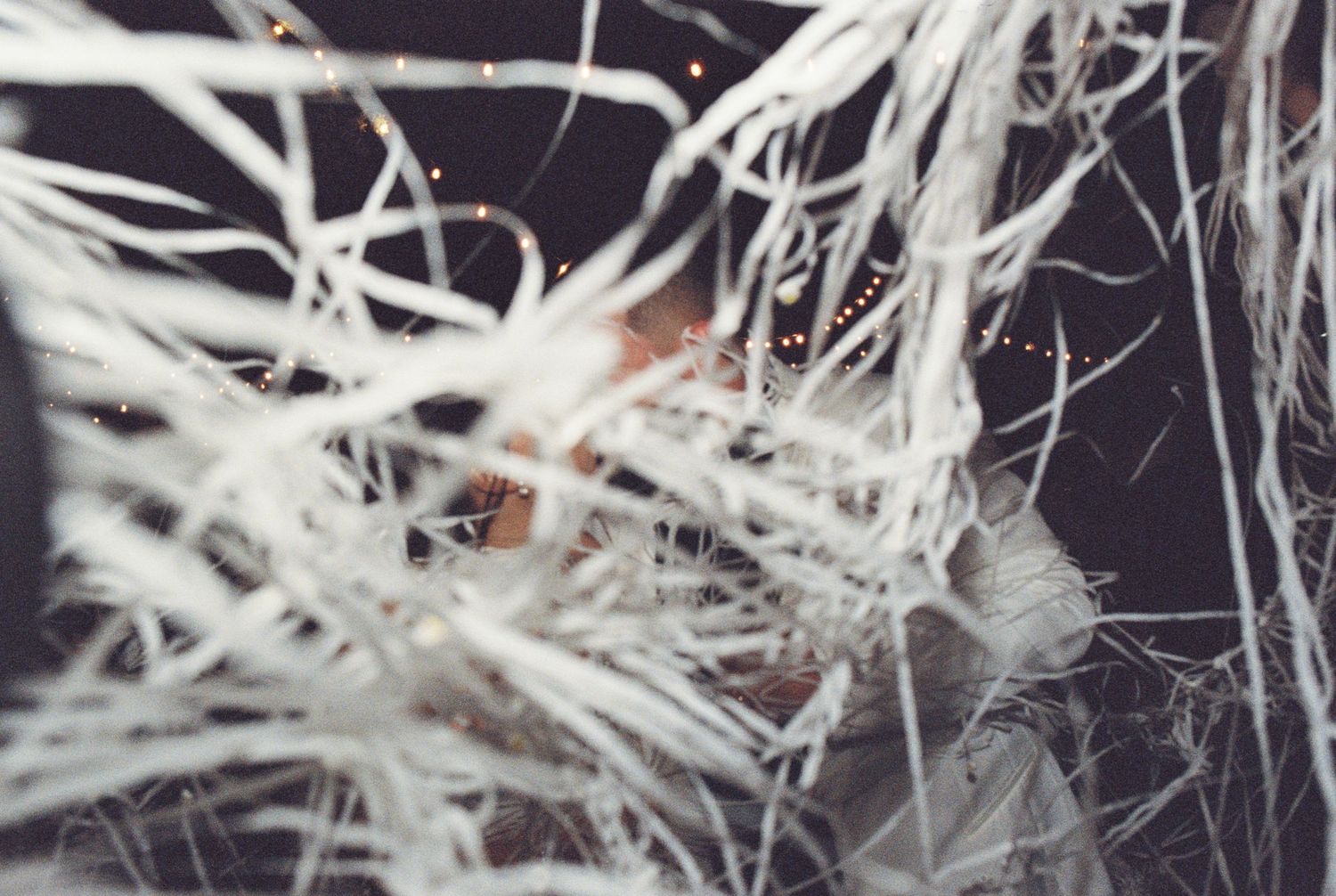 Abstract view of white streamers and party decorations creating artistic patterns at night.