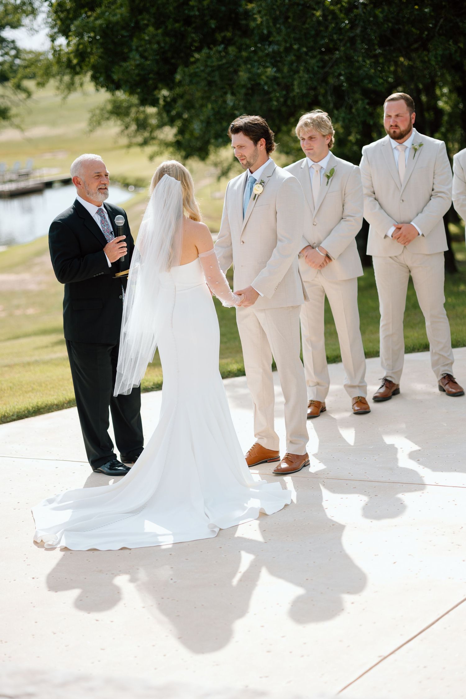 Outdoor wedding ceremony with light beige attired wedding party.