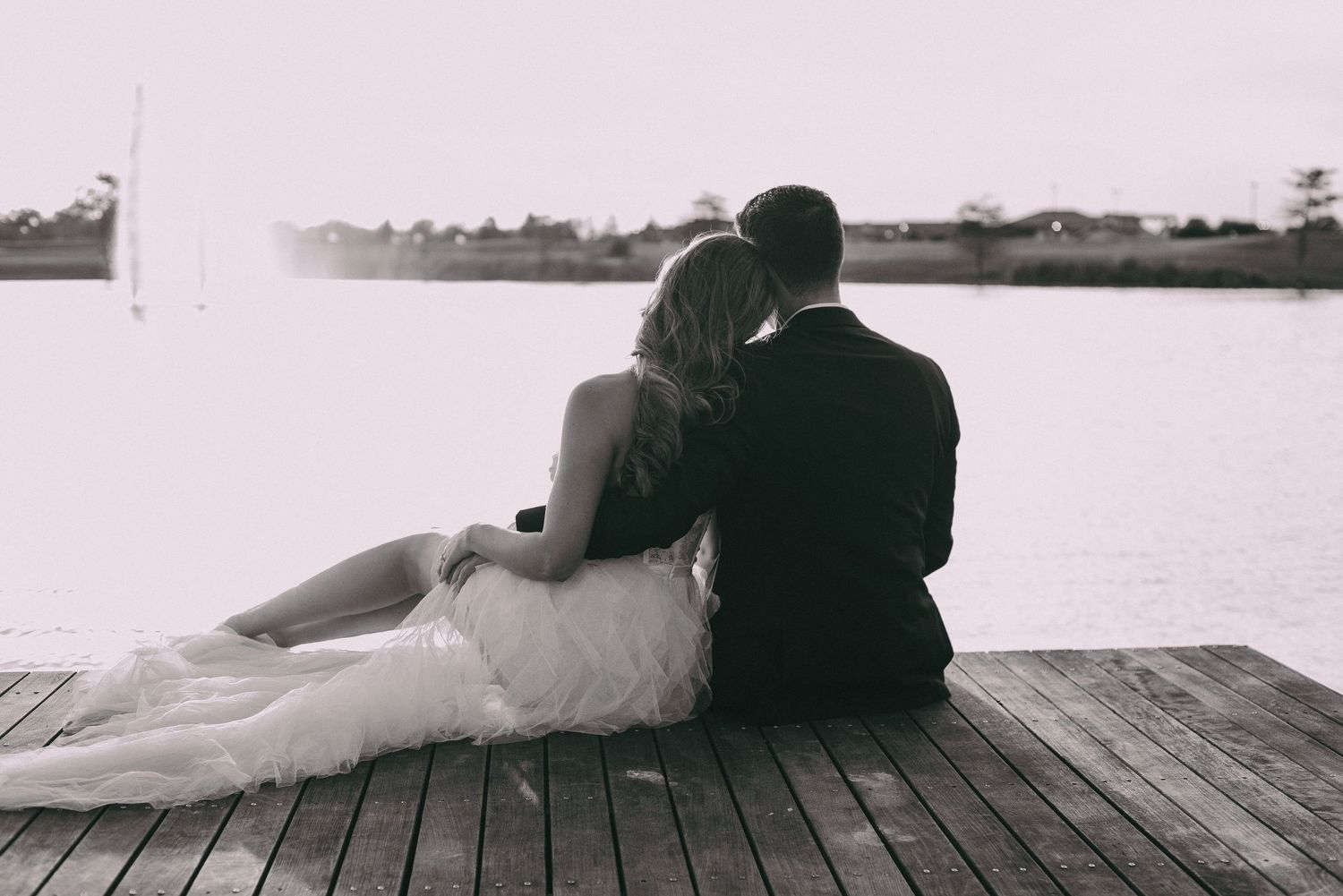 Silhouette of a couple sitting together on a wooden dock at sunset in Bryan Texas