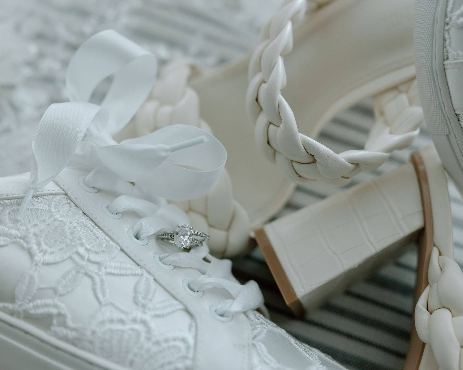Close-up of wedding ring placed on white lace sneaker.