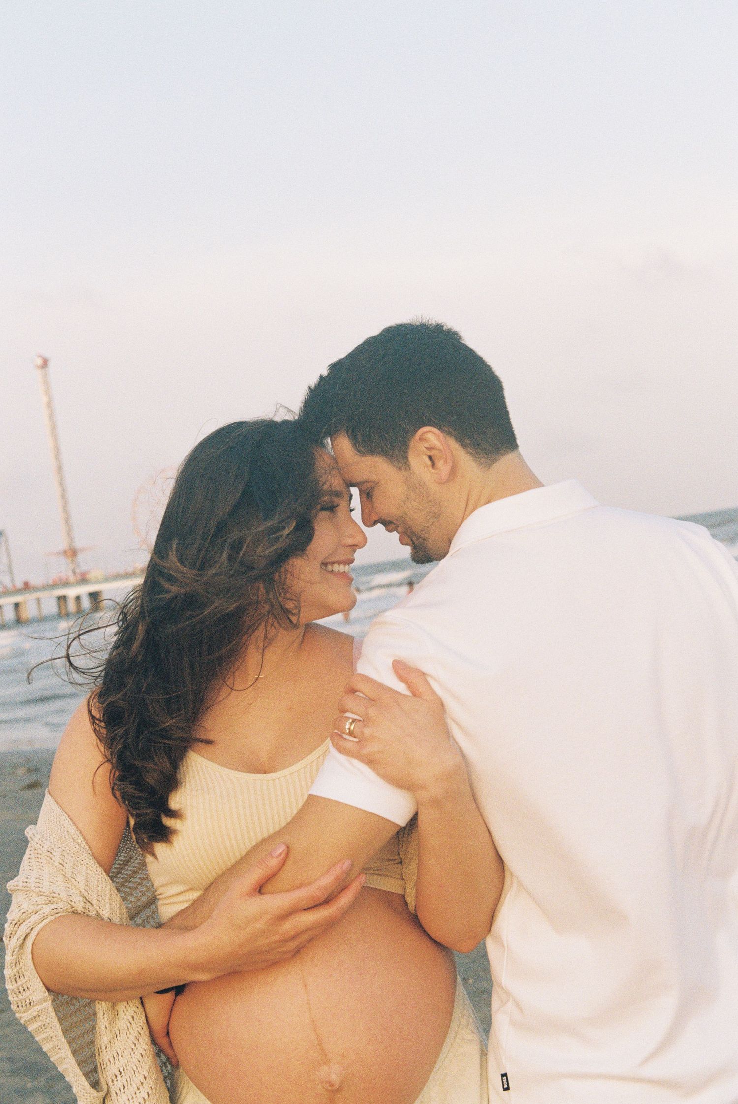 A tender moment captured between a couple during their beach maternity session.