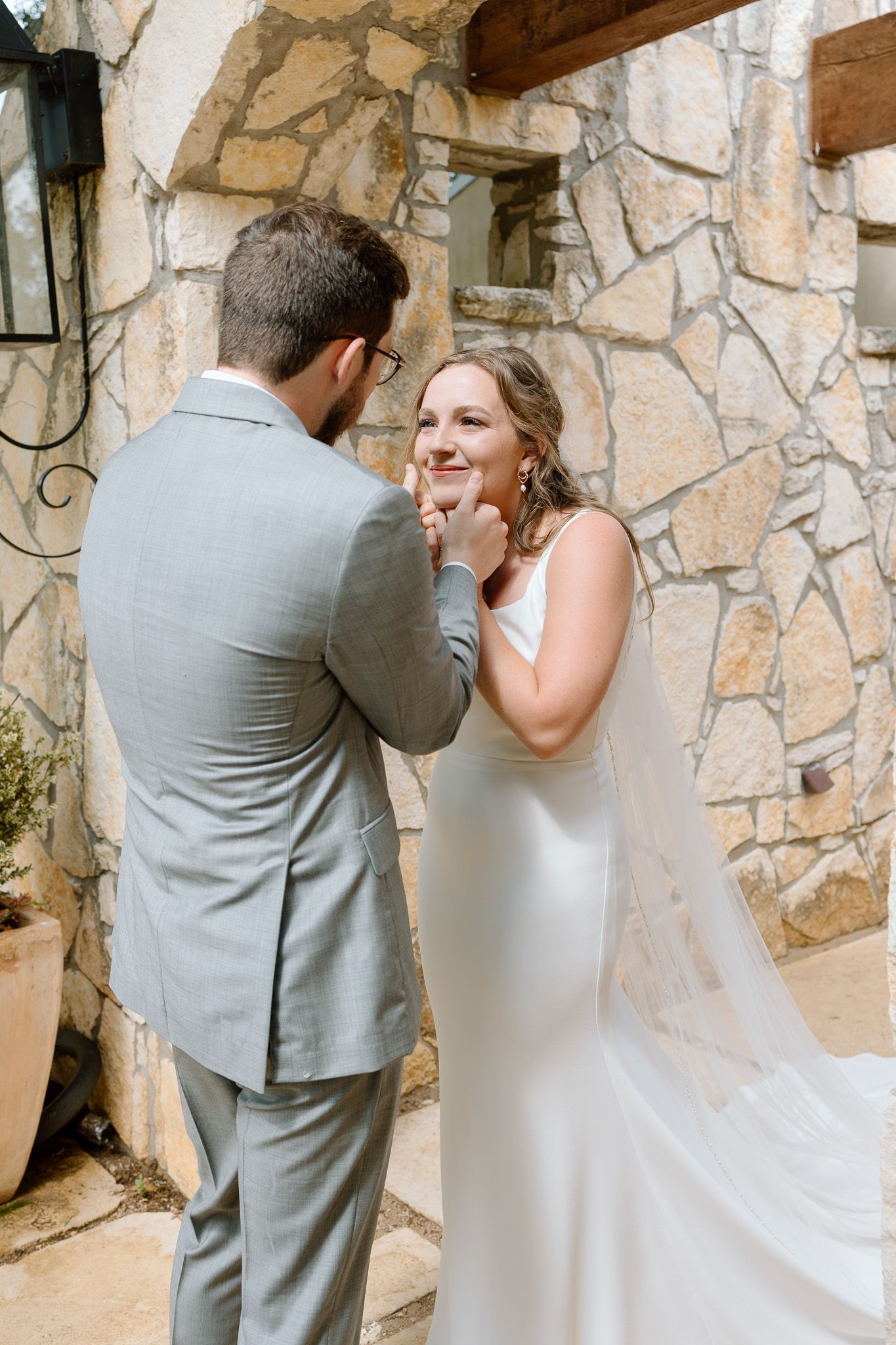 A tender moment captured between a couple during their first look at a stone wall venue.