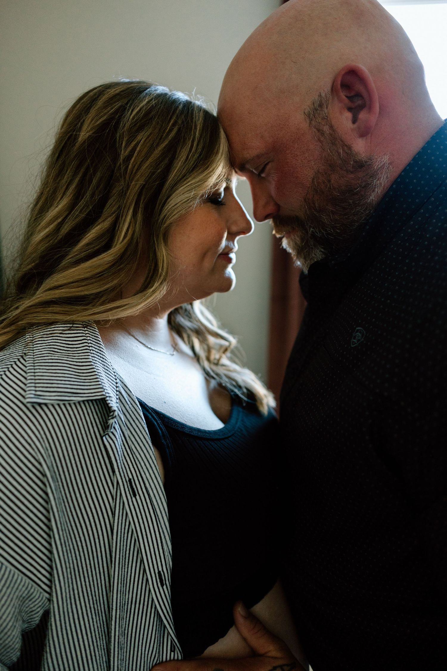 An intimate close-up of a couple sharing a tender moment indoors.