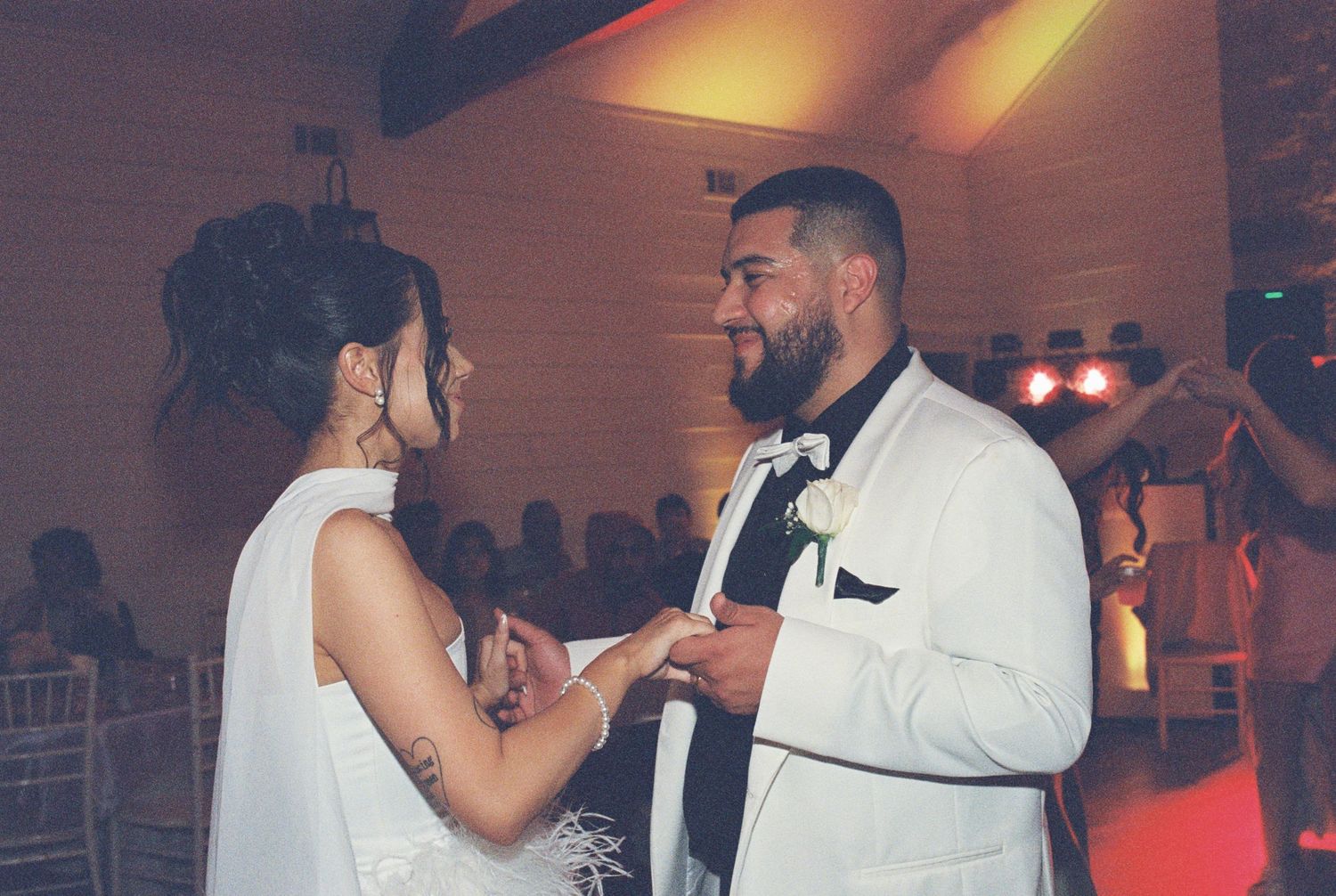 A couple dancing together at their wedding reception in formal attire.