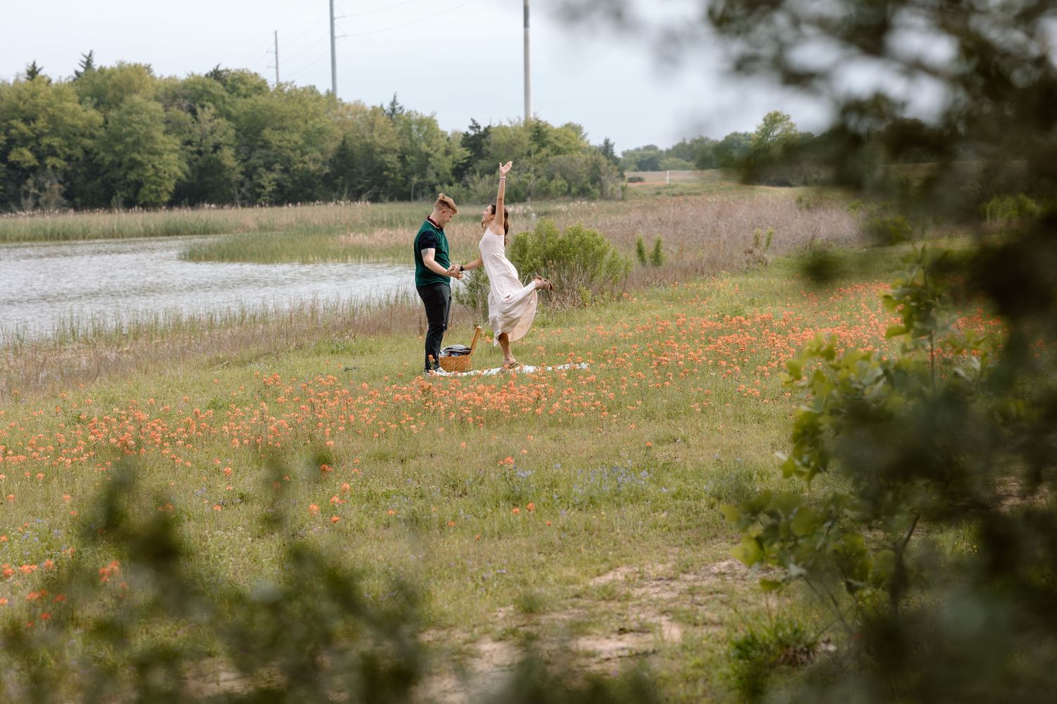 A couple walking together through a wildflower meadow with a lake in the background documentary photography college station Texas.