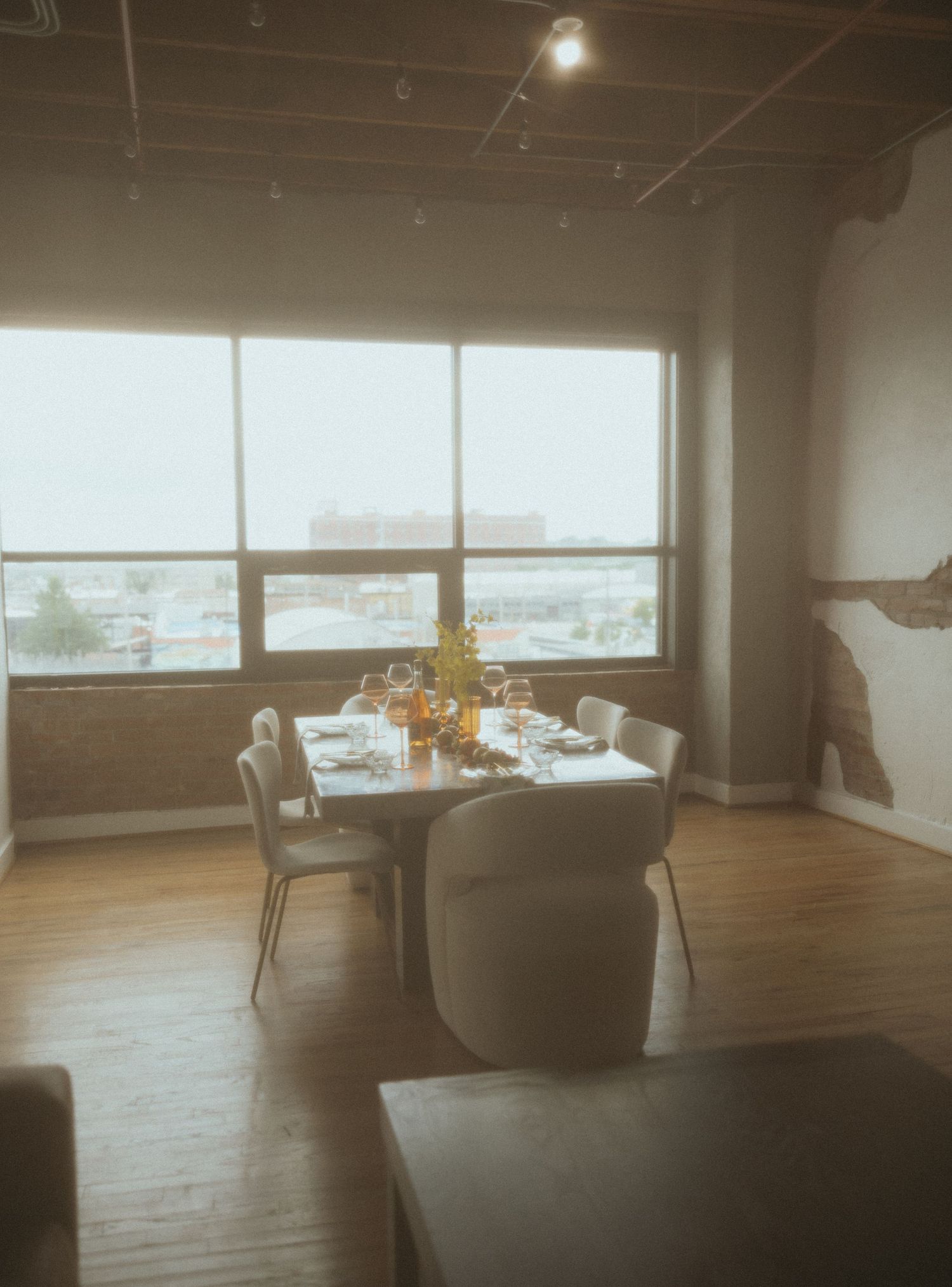 Modern dining room setup with large windows and minimalist furniture in natural light.