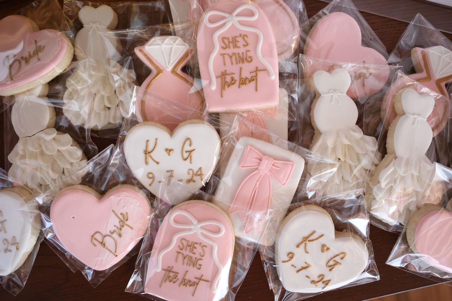 Pink and white heart-shaped cookies decorated with romantic messages and delicate icing designs.
