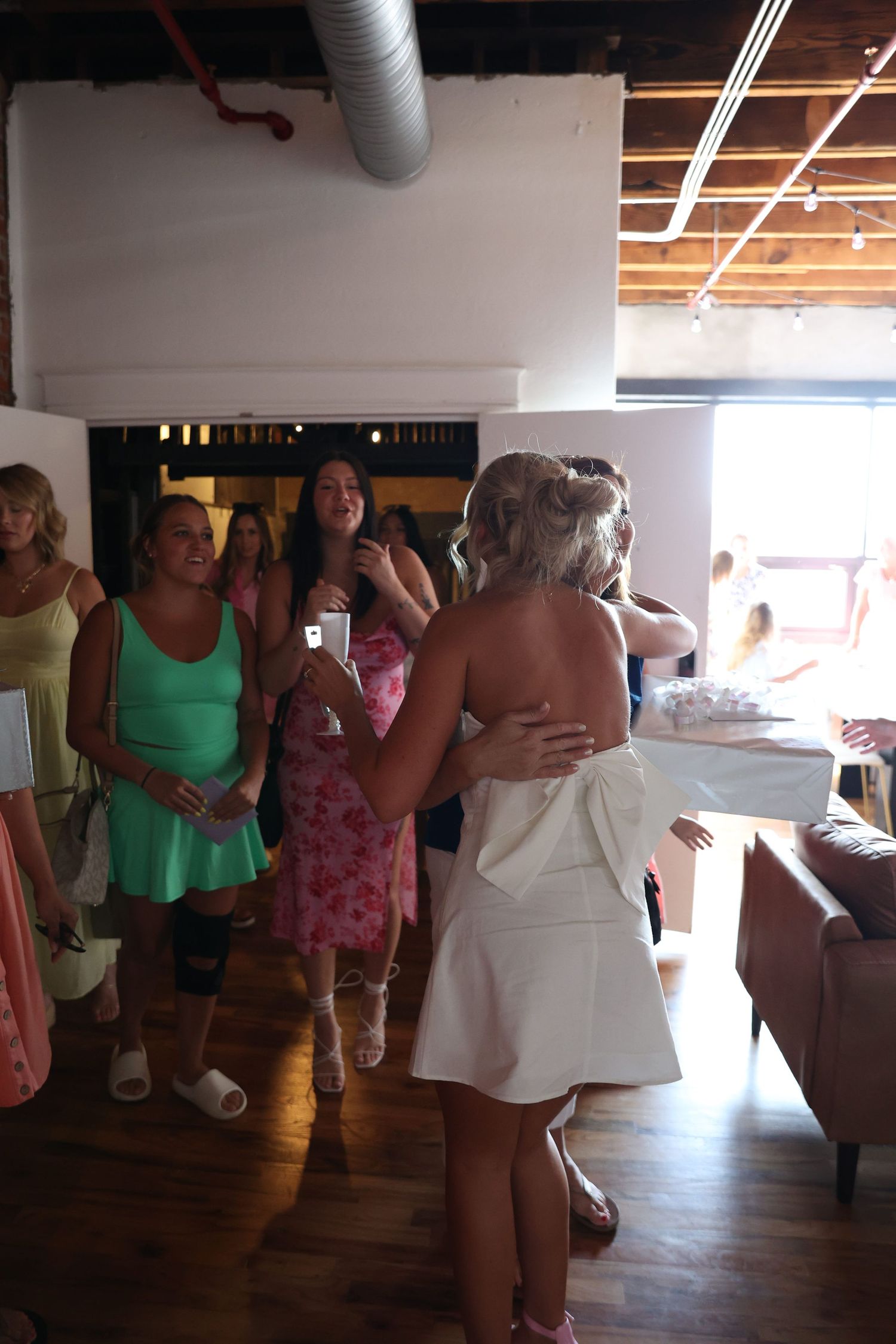 Gathering in a loft-style room with exposed brick and ductwork.