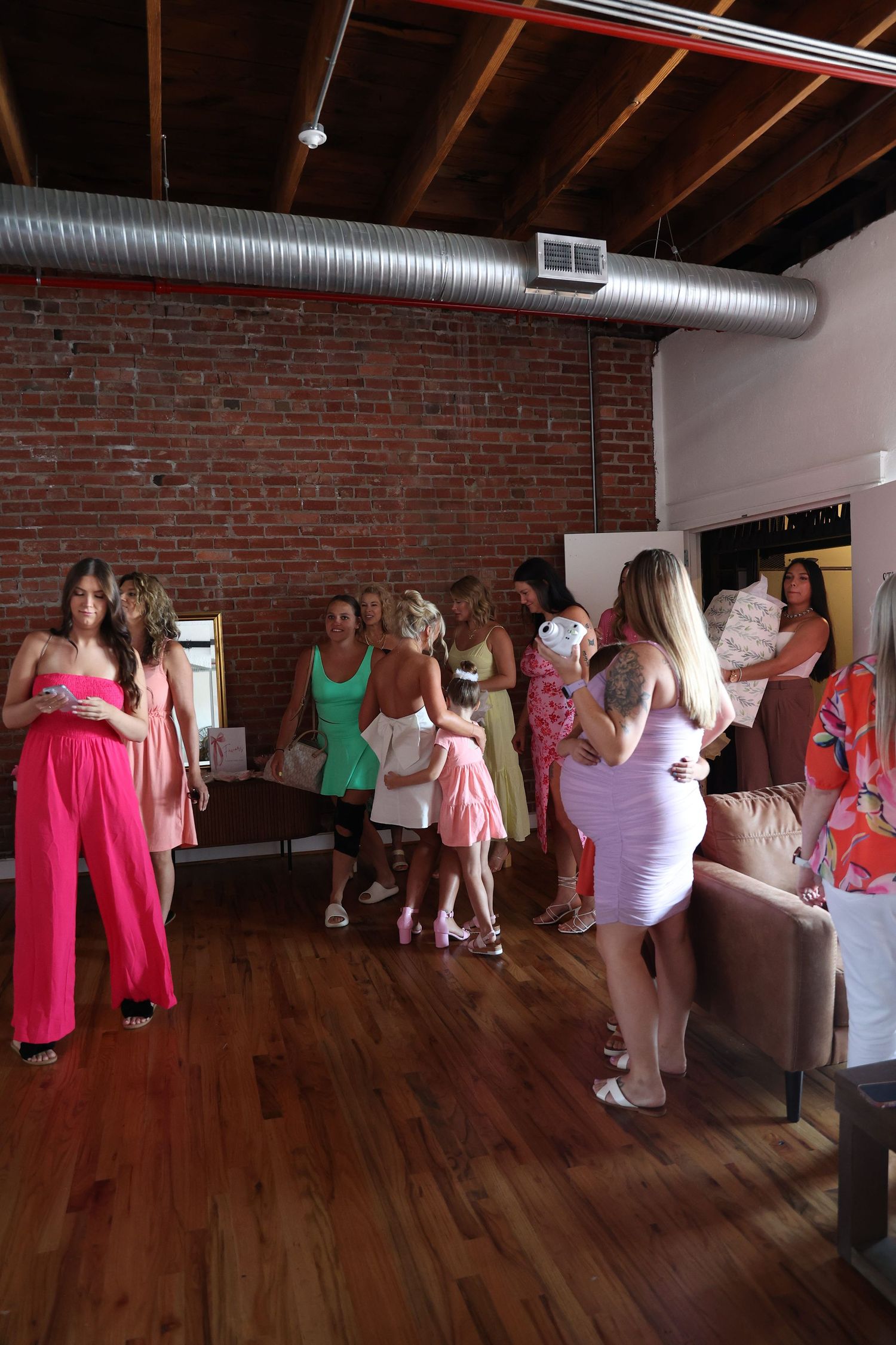 Social gathering in a modern loft space with exposed brick and ductwork.