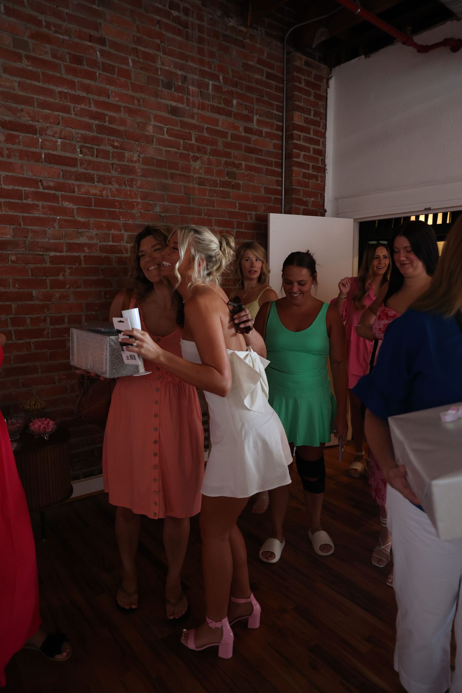 Group celebration in an industrial style room with brick walls and wooden floors.