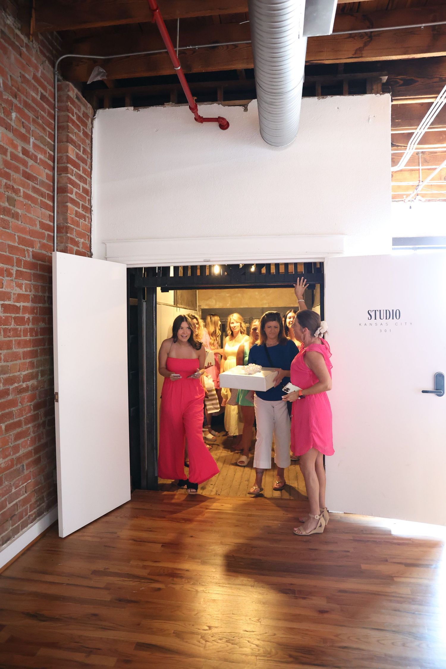 Interior of a studio space with exposed brick walls and hardwood floors.