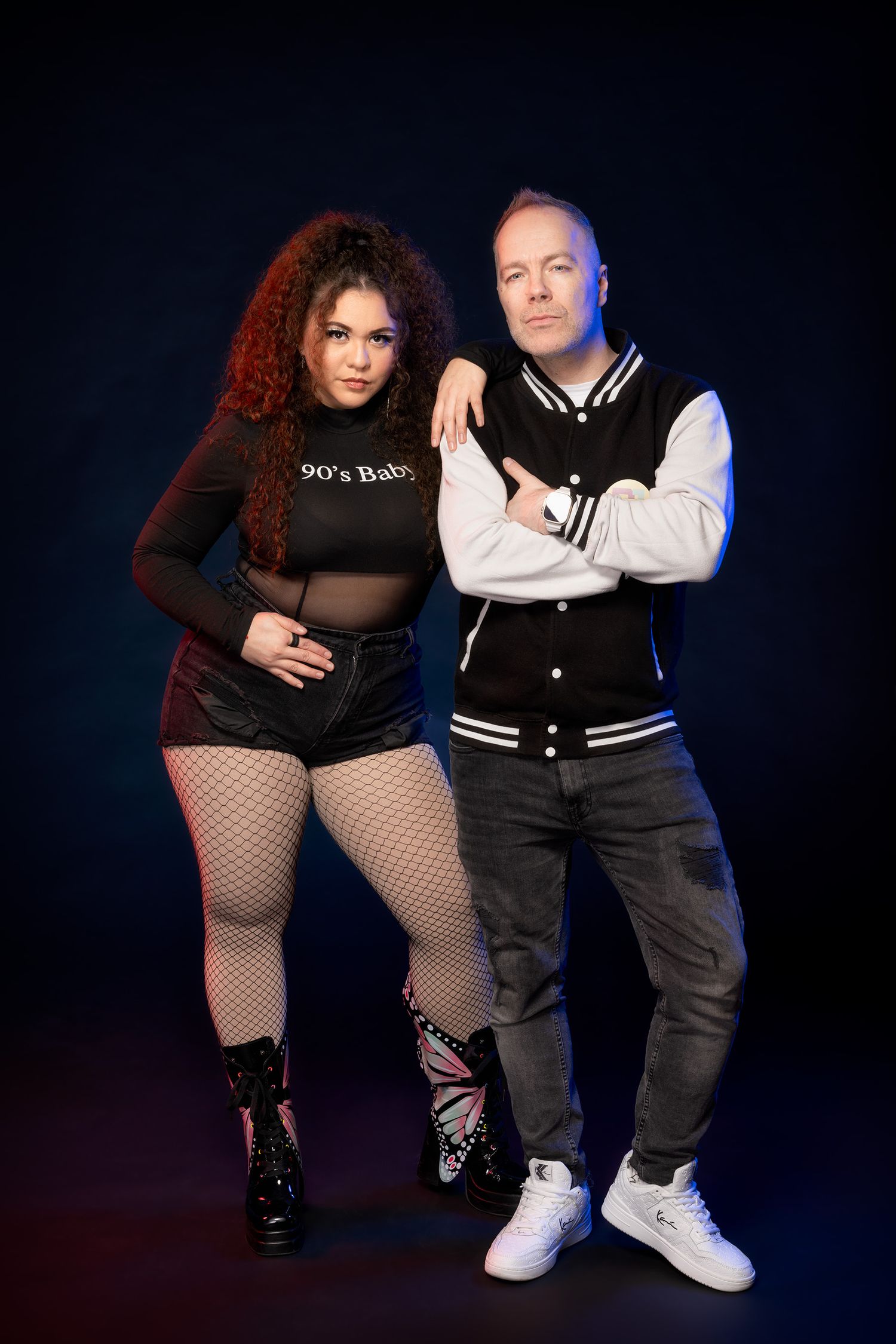 DJ Kite ja laulaja Astrid Nicole poseeraavat vierekkäin mustaa taustaa vasten.