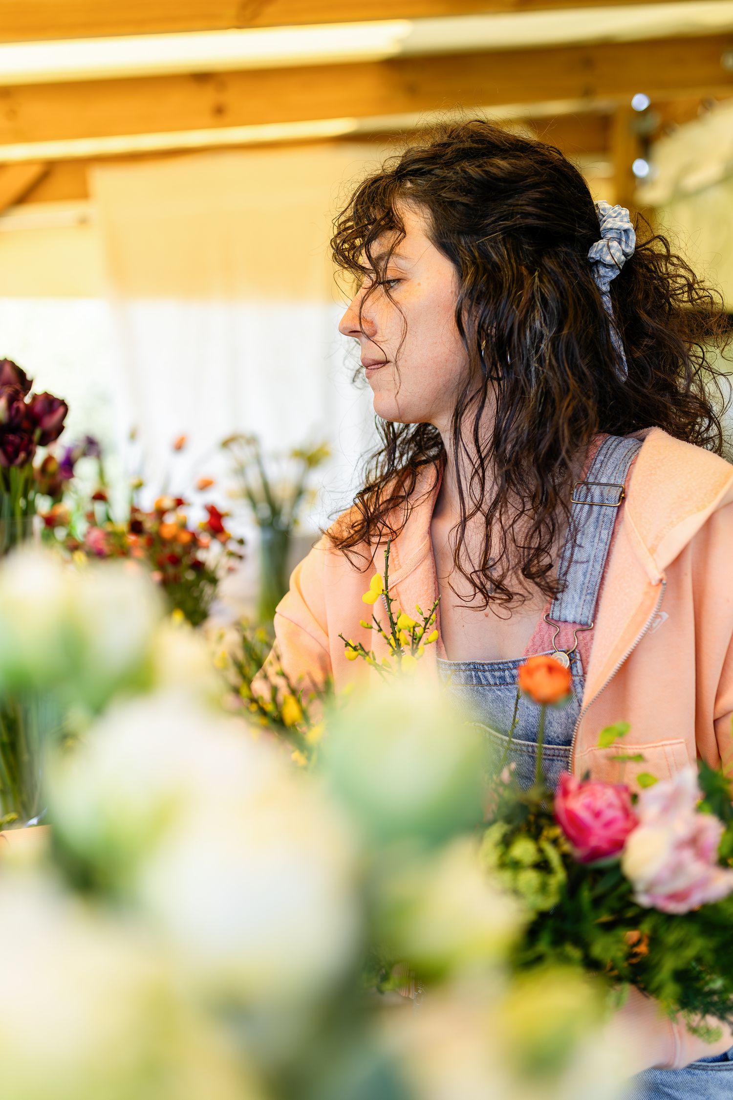 Floricultrice en pleine activité dans sa serre, travail artisanal des fleurs