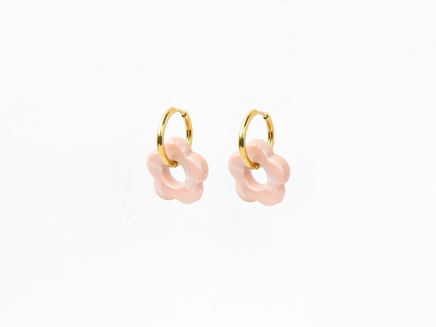 Photo en packshot d’une paire de boucles d'oreilles, mise en valeur des détails et du design sur fond neutre et lumineux. Bijoux.