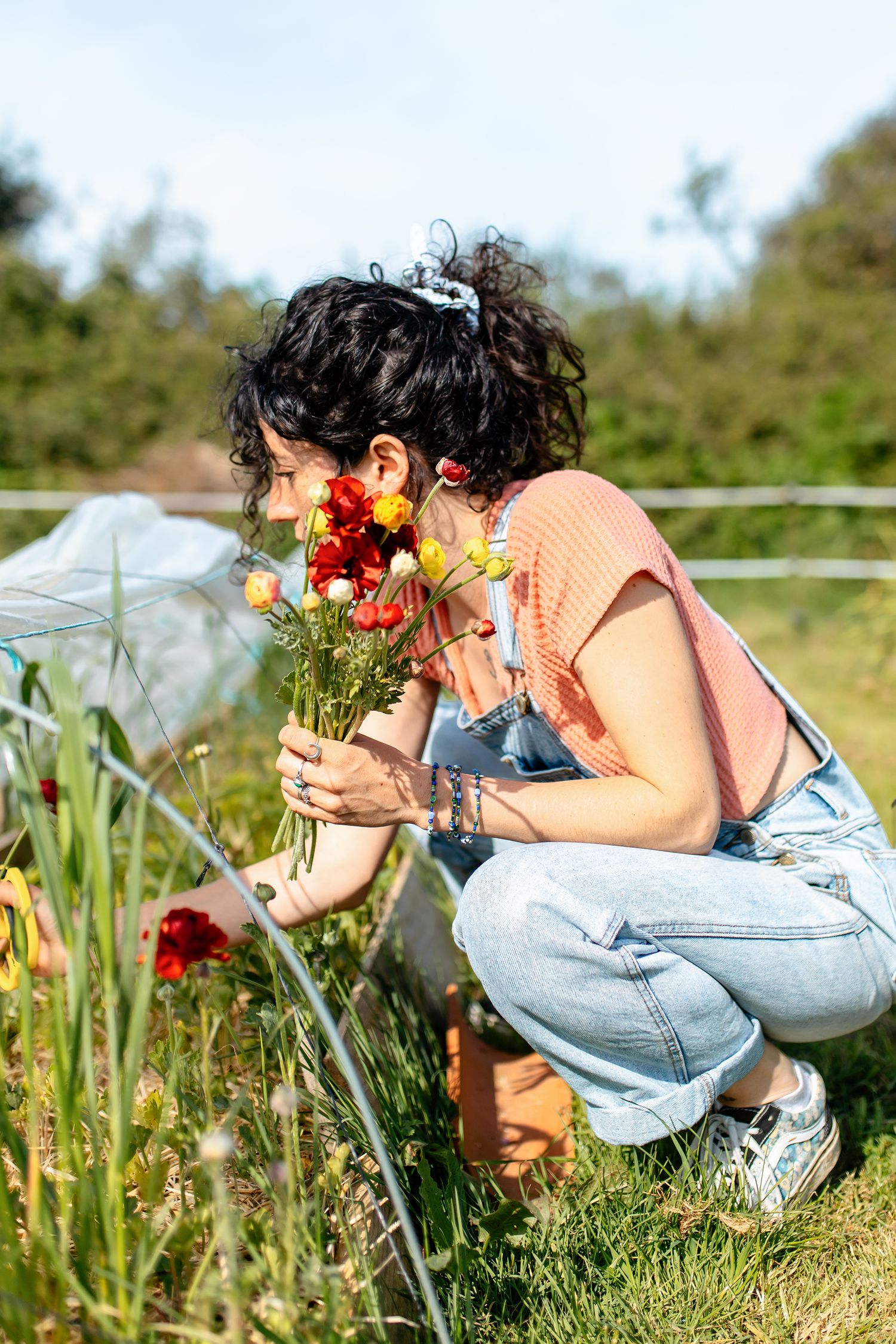 Floricultrice en pleine activité dans sa serre, travail artisanal des fleurs