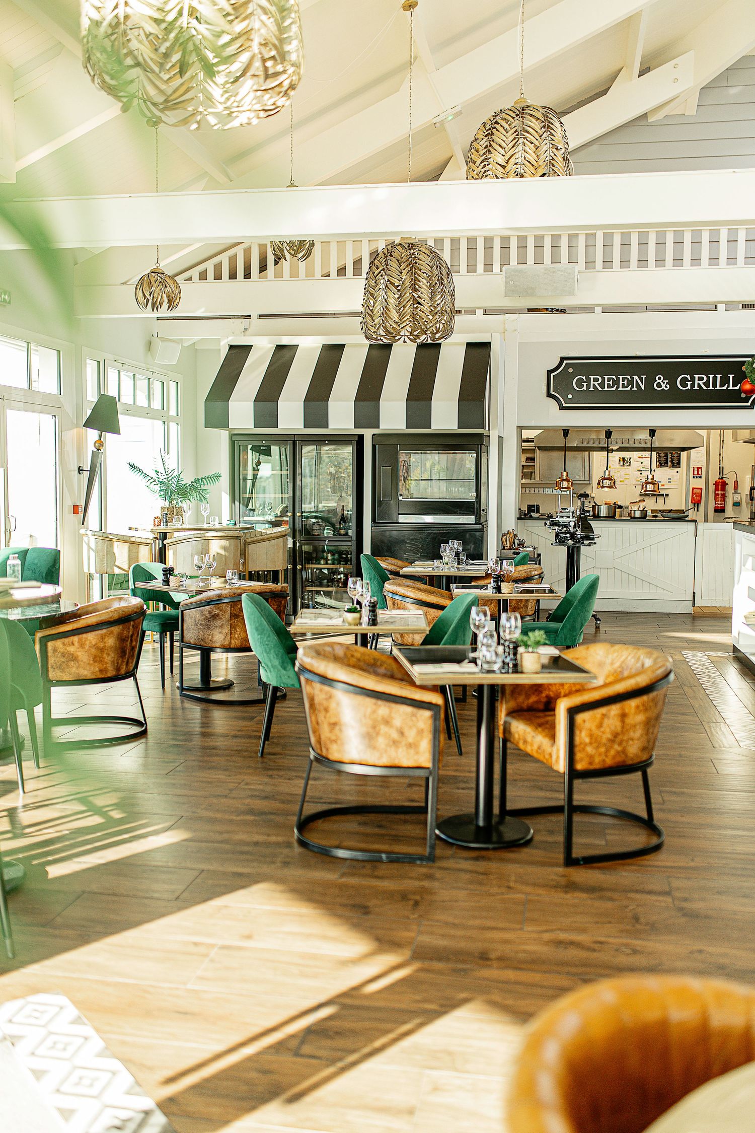 Photo d’un restaurant élégant, tables dressées avec décor raffiné et ambiance chaleureuse sous une lumière tamisée.