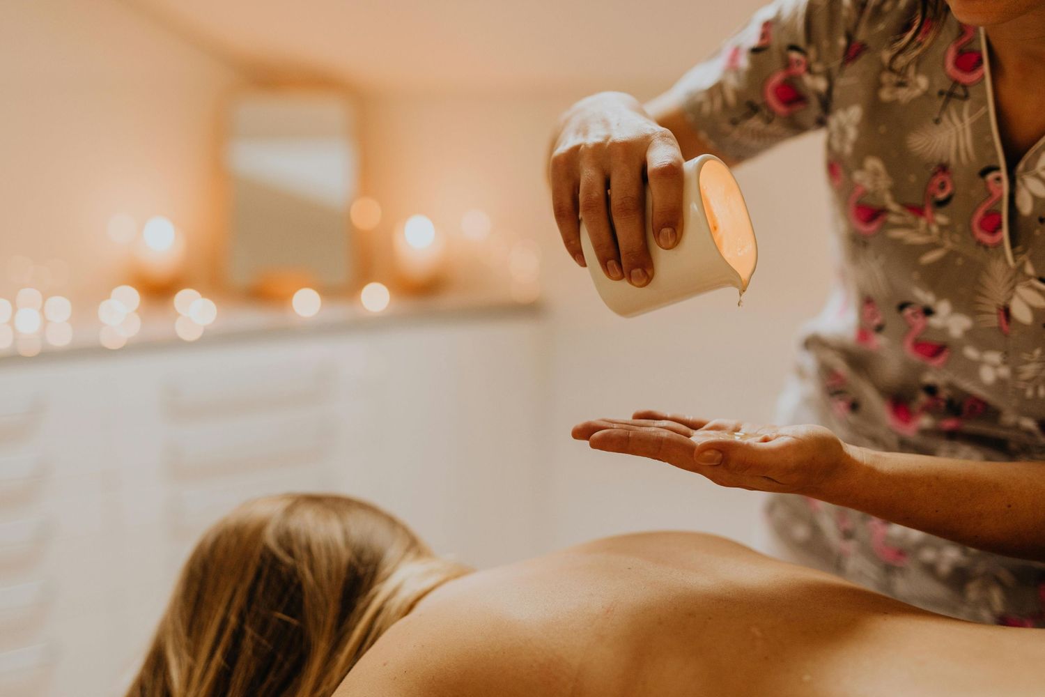 Photo dans un spa, masseuse en action réalisant un massage relaxant, ambiance calme et apaisante avec lumière tamisée.