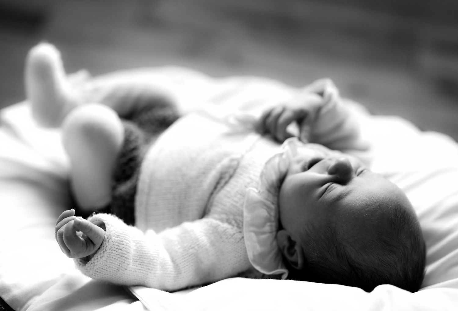 Serene black and white images of newborn baby resting peacefully.