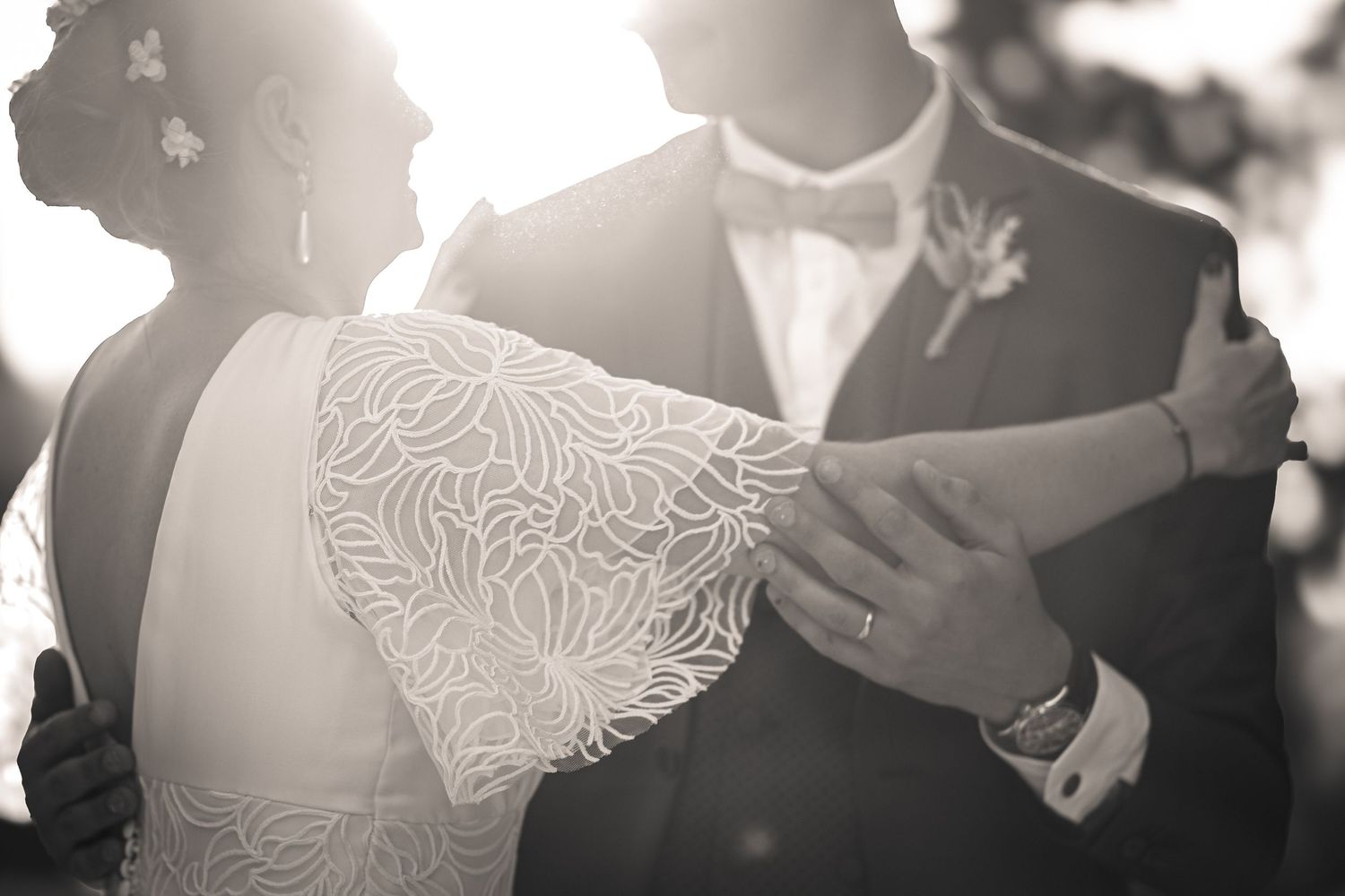 Artistic silhouette of newlyweds sharing a romantic kiss in dreamy lighting.