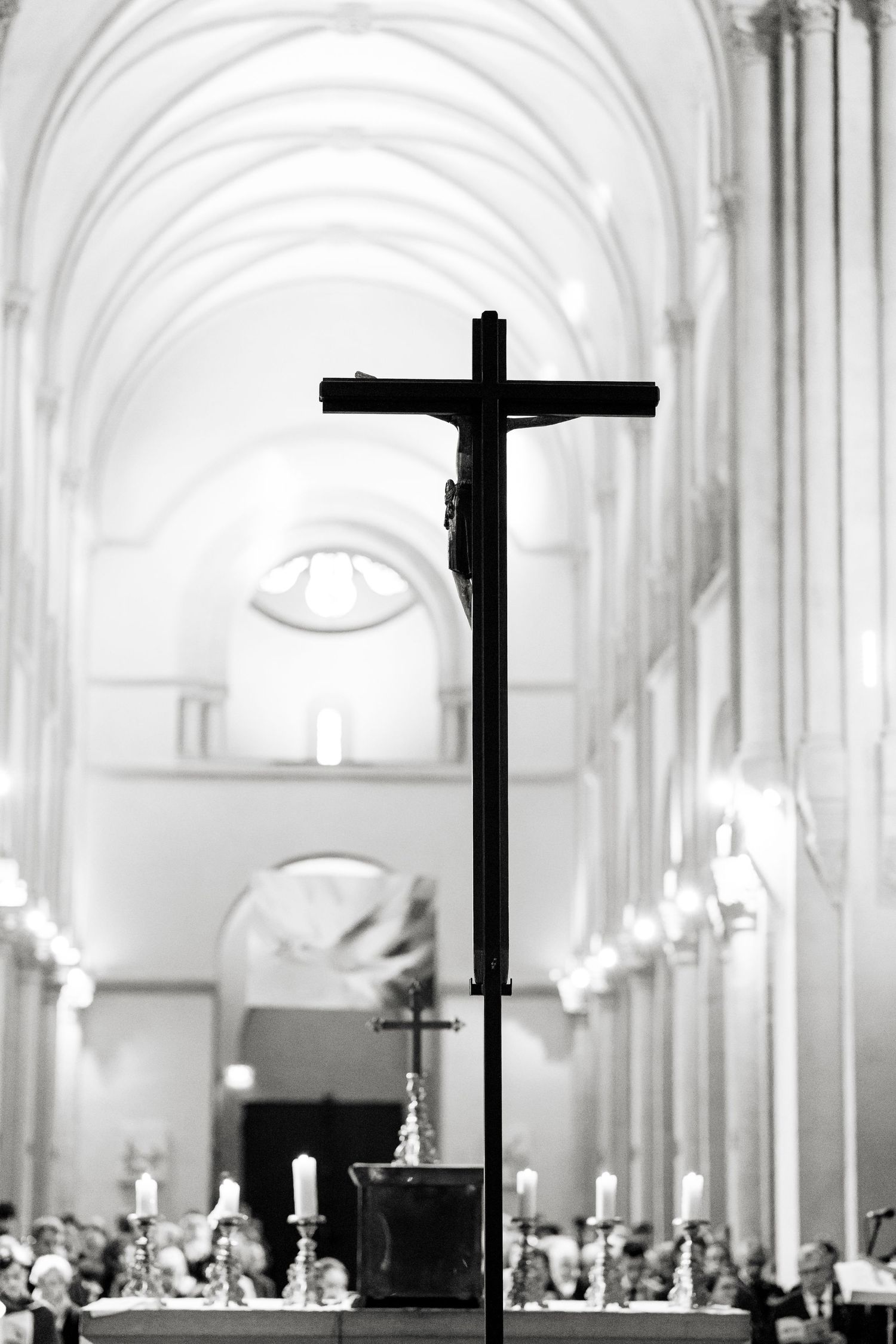 A black and white photograph shows a grand church interior with arched ceilings, crosses, and a congregation gathered inside.