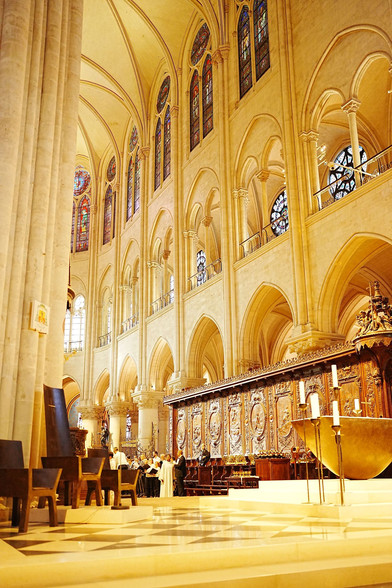 Gothic cathedral interior with vaulted ceilings and stained glass windows bathed in warm light.
