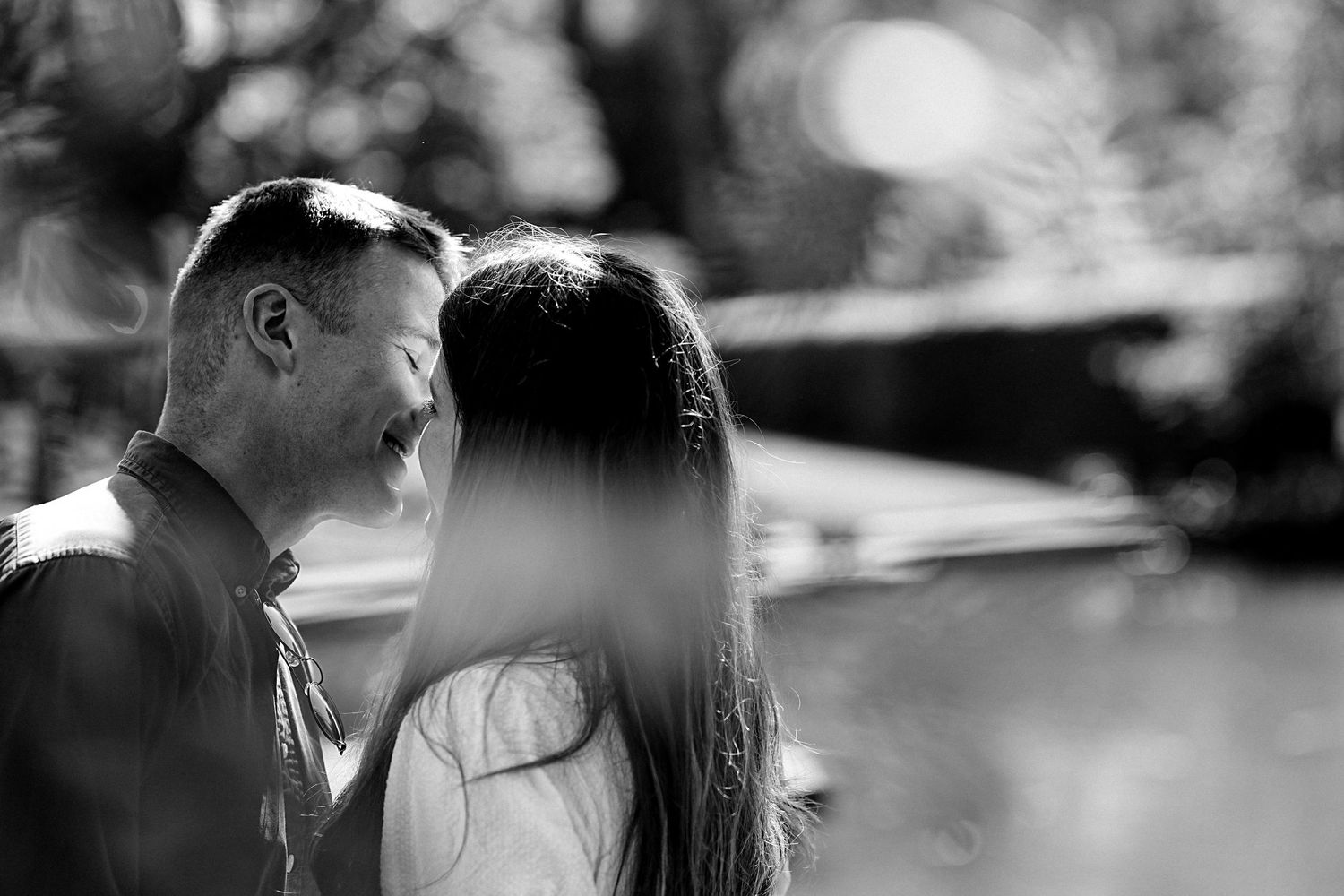 Black and white portrait of couple sharing tender moments in natural light.