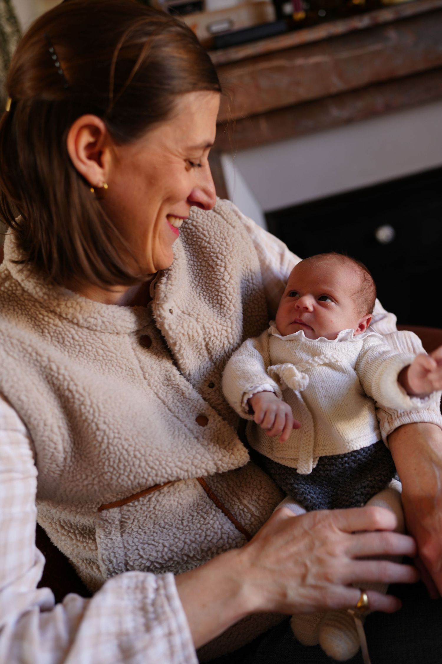 Parent and baby sharing a joyful moment together in cozy indoor lighting.