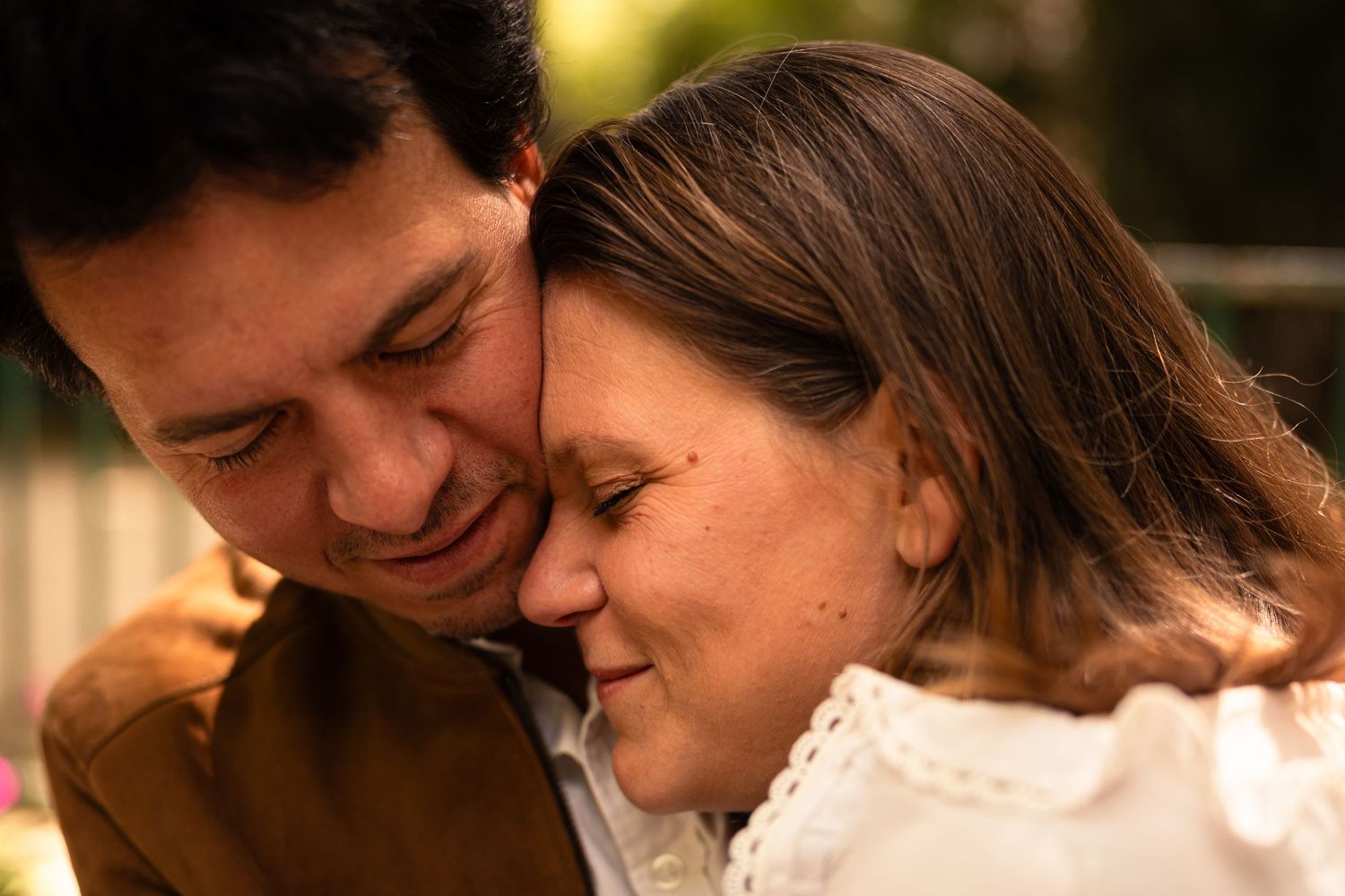 Intimate close-up of a tender moment between a couple in warm sunset lighting.