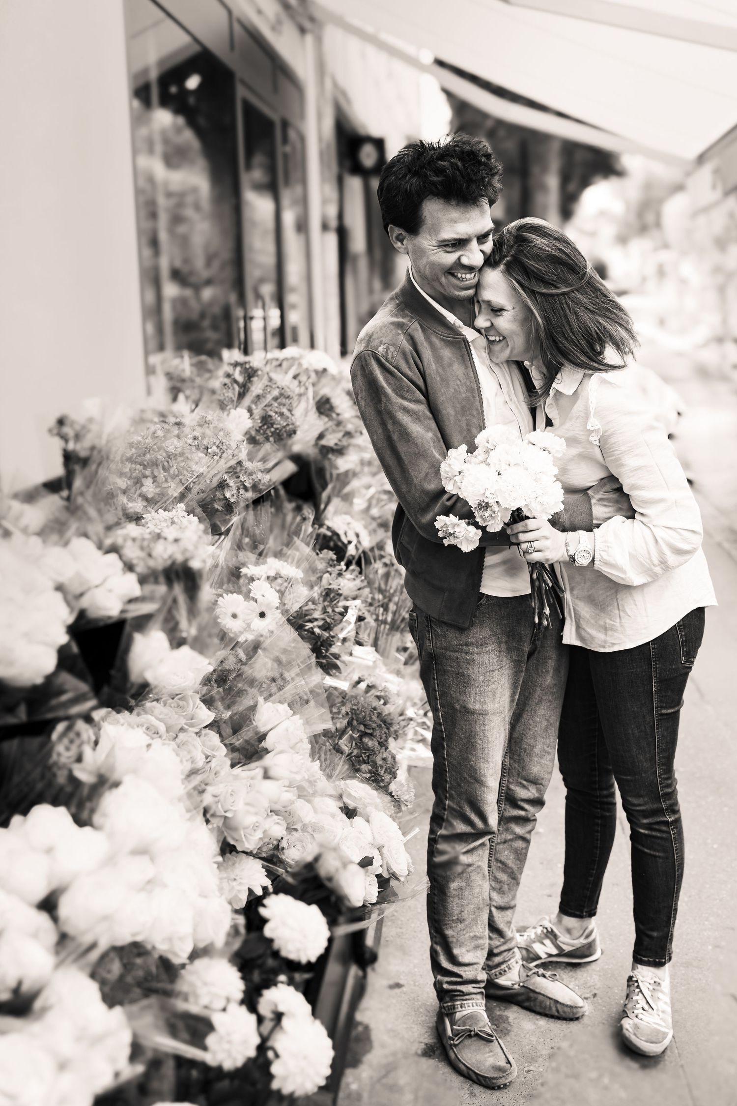 Black and white image showing couple with elegant white floral decorations.
