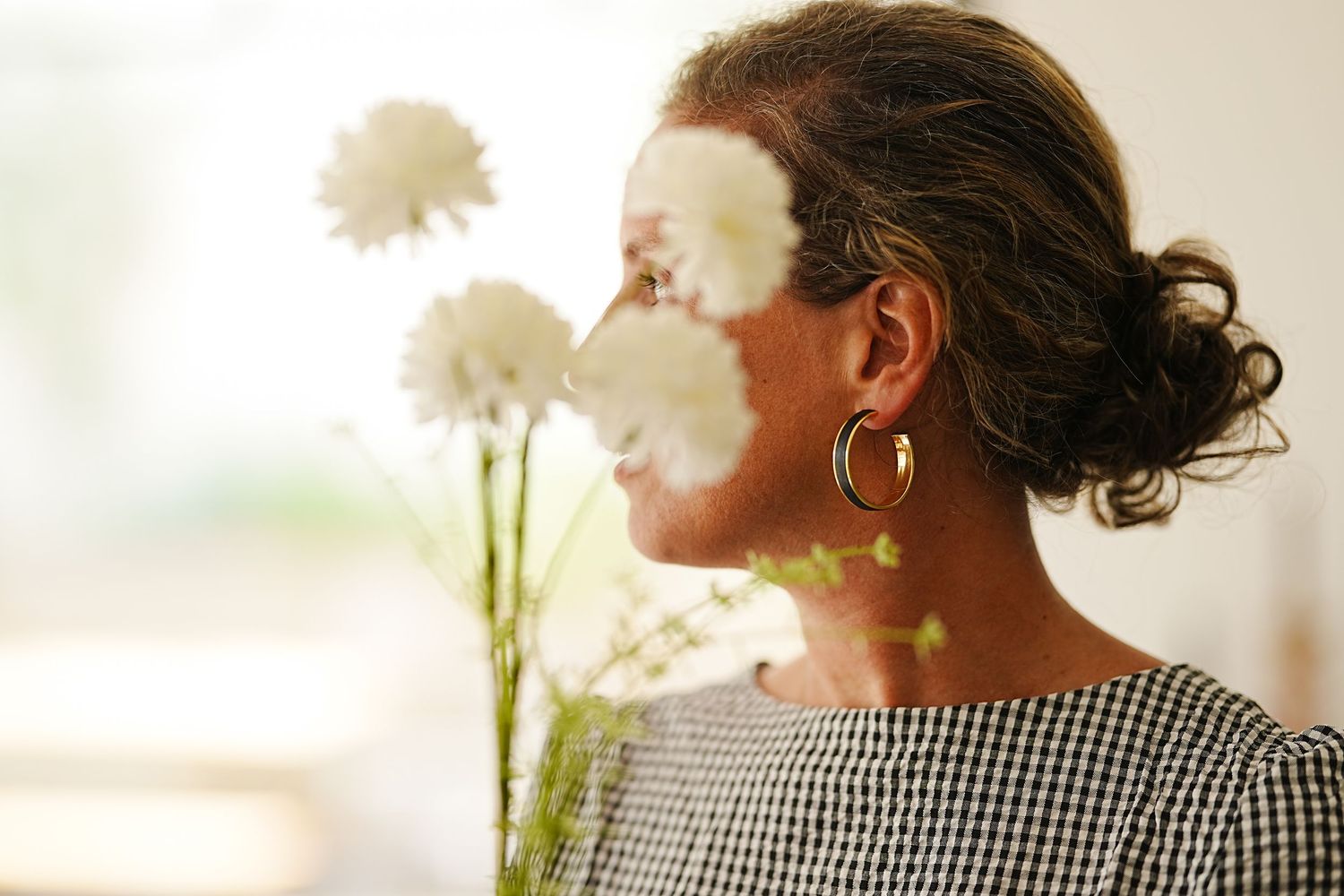 Soft focus portrait with sunlit flowers creating a dreamy atmosphere.