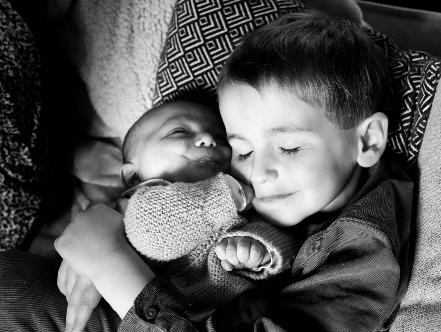 Black and white image of peaceful sleeping figures cuddling together.