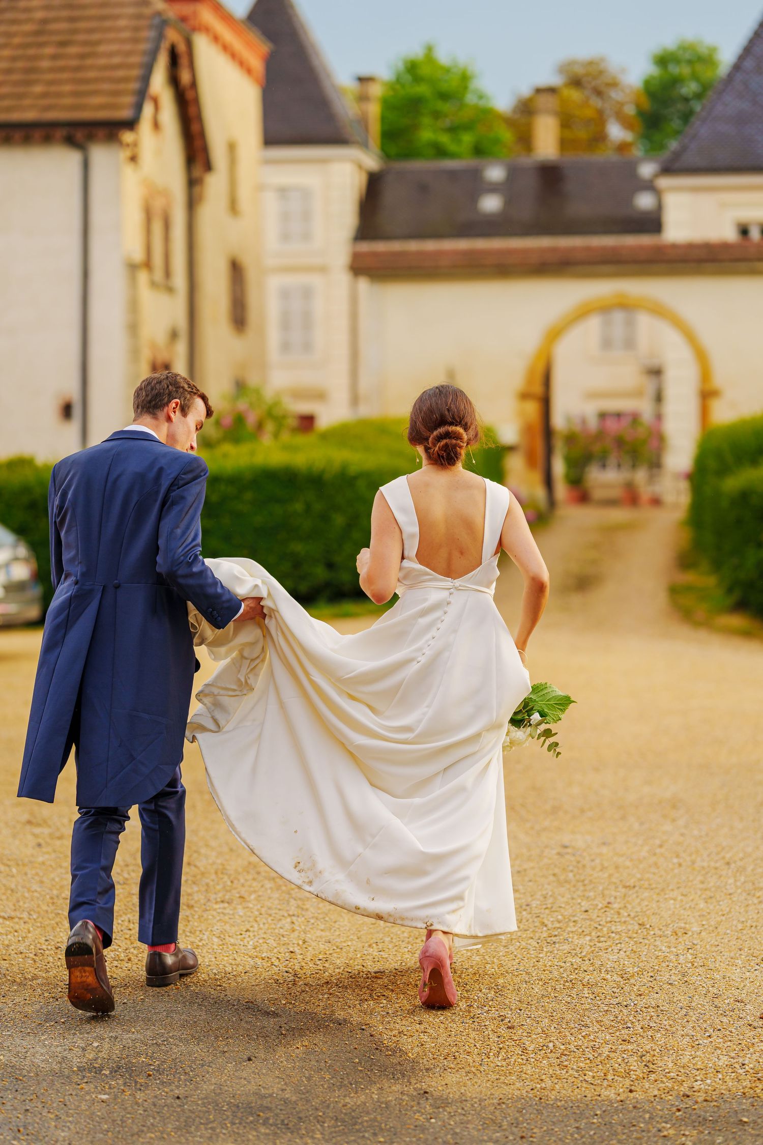 A series of playful wedding portraits showing the couple's feet and dress movements on a gravel courtyard.