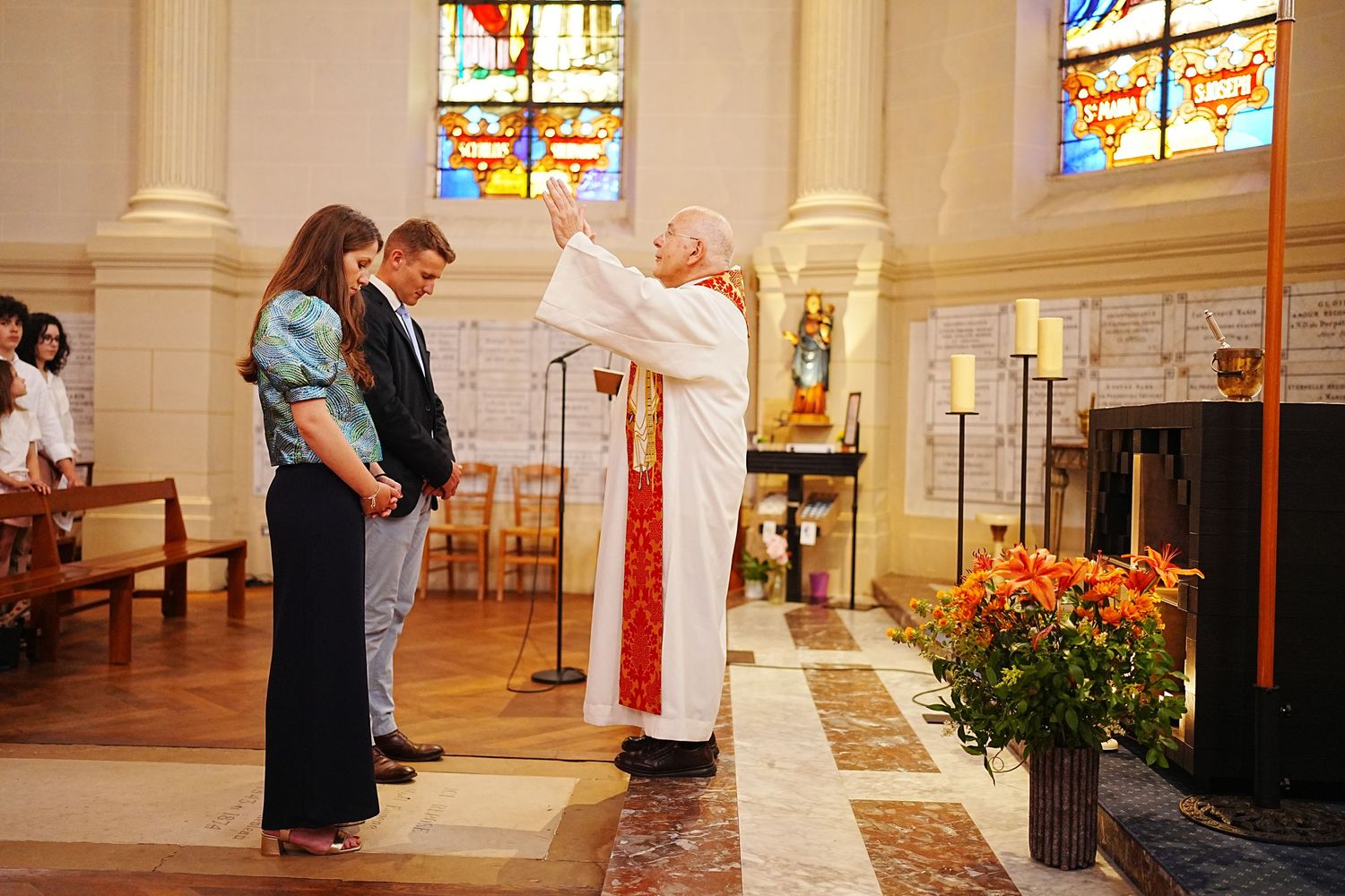 Church interior with stained glass windows showing couple in romantic poses.