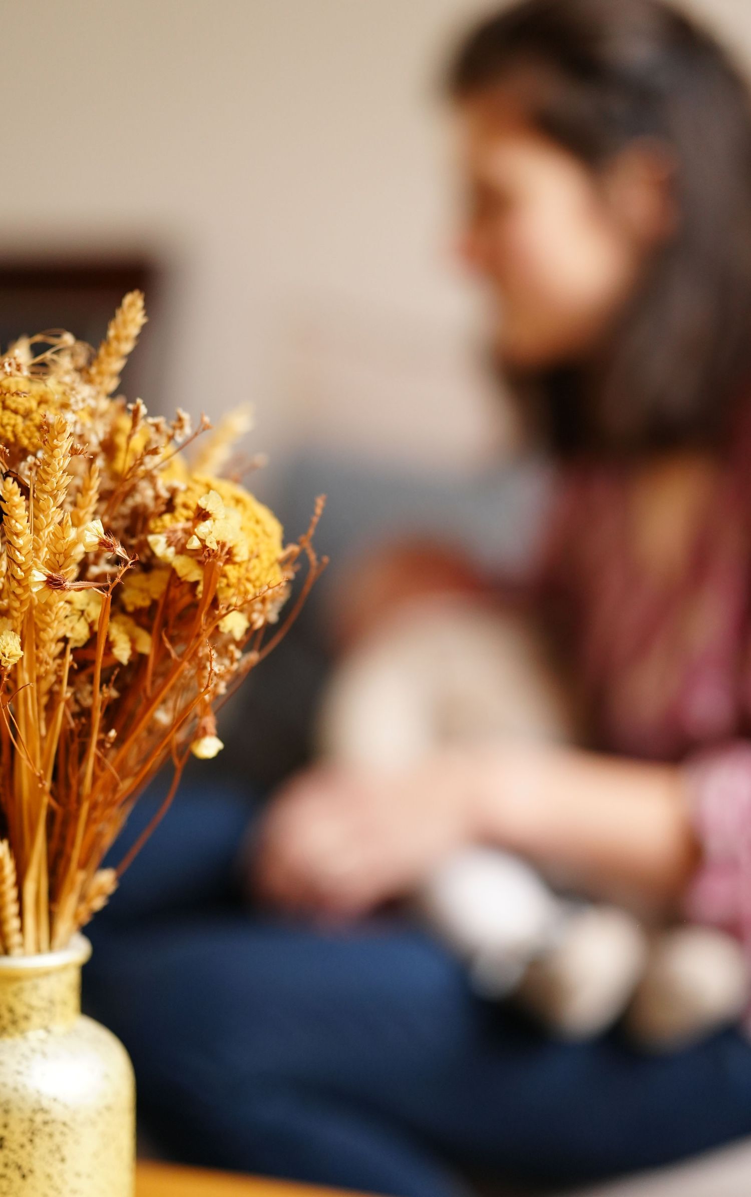 Dried golden flowers in a vase with blurred background creating a cozy atmosphere.