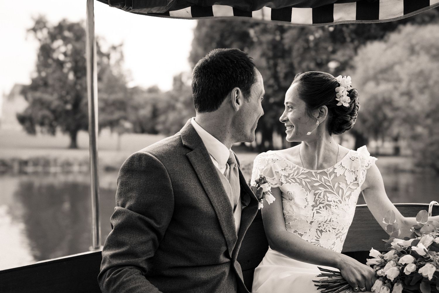 Black and white wedding photos show romantic moments between newlyweds at an outdoor venue.