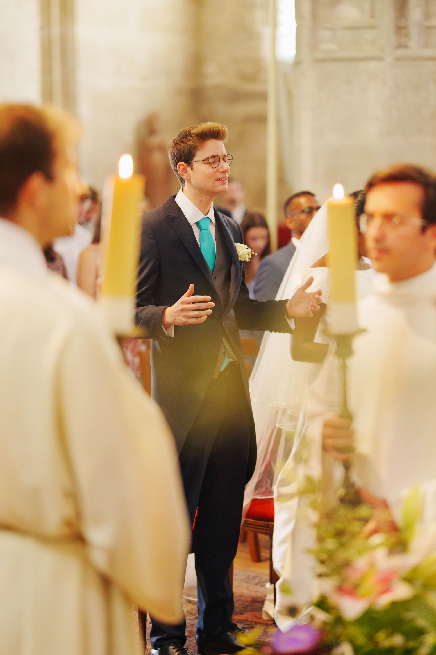 Wedding ceremony in progress with clergy and candles in ornate church setting.