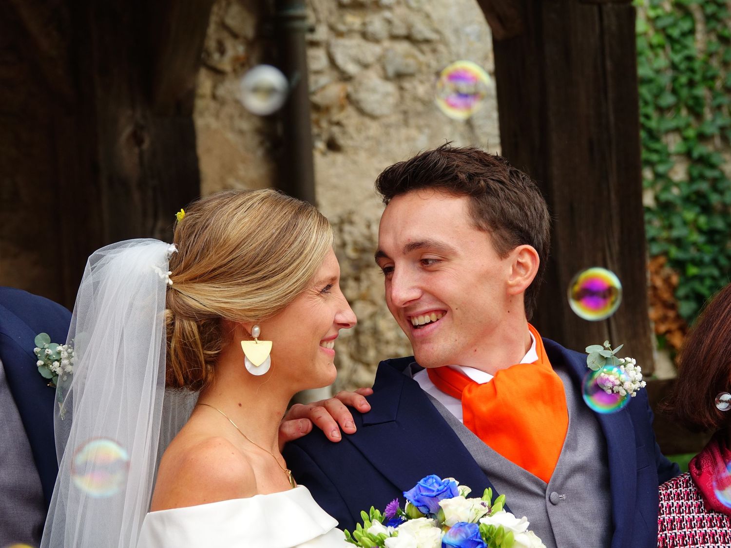 Wedding celebration outdoors with bubbles floating in the air.