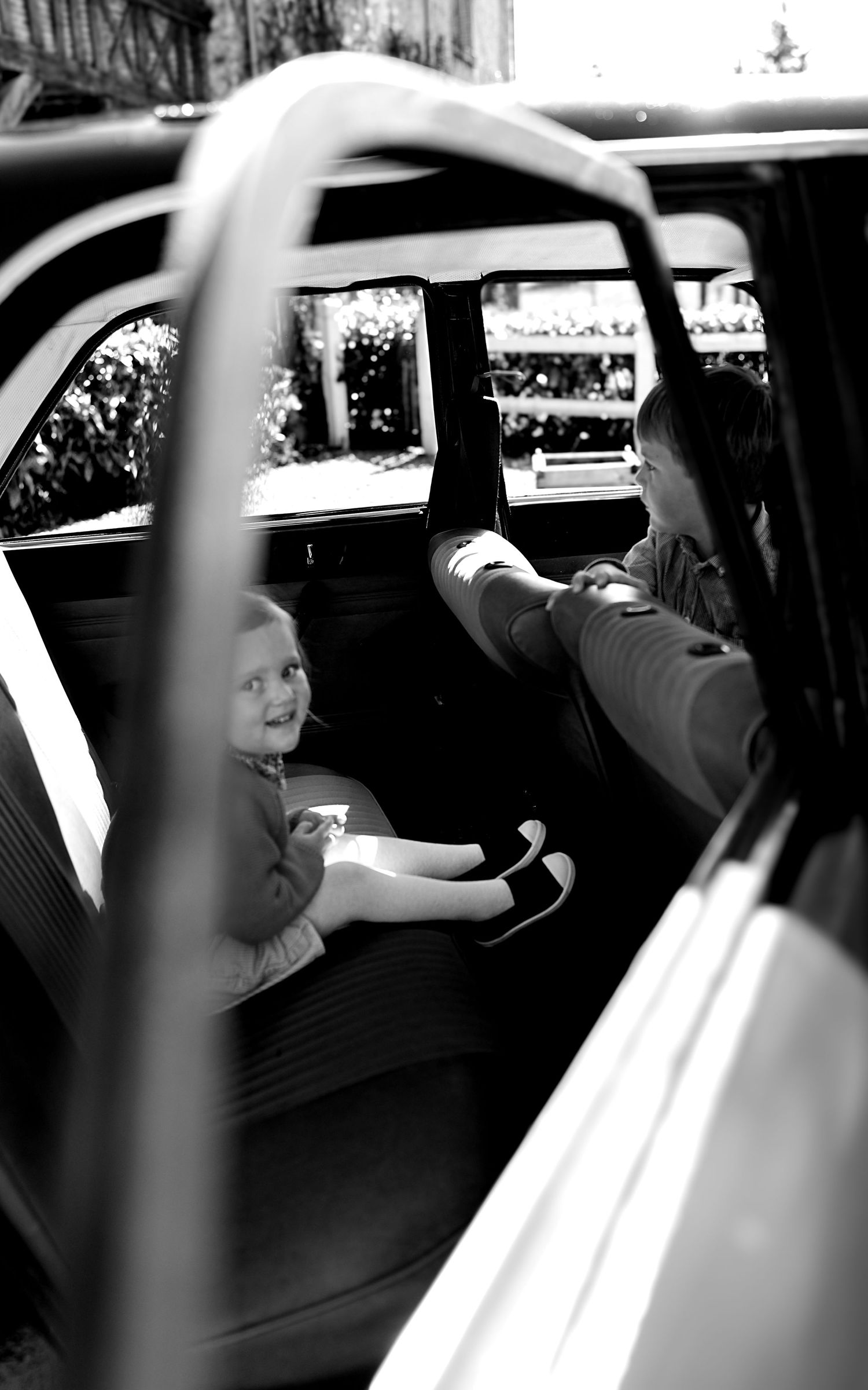 Black and white sequence showing movement inside a vintage automobile.
