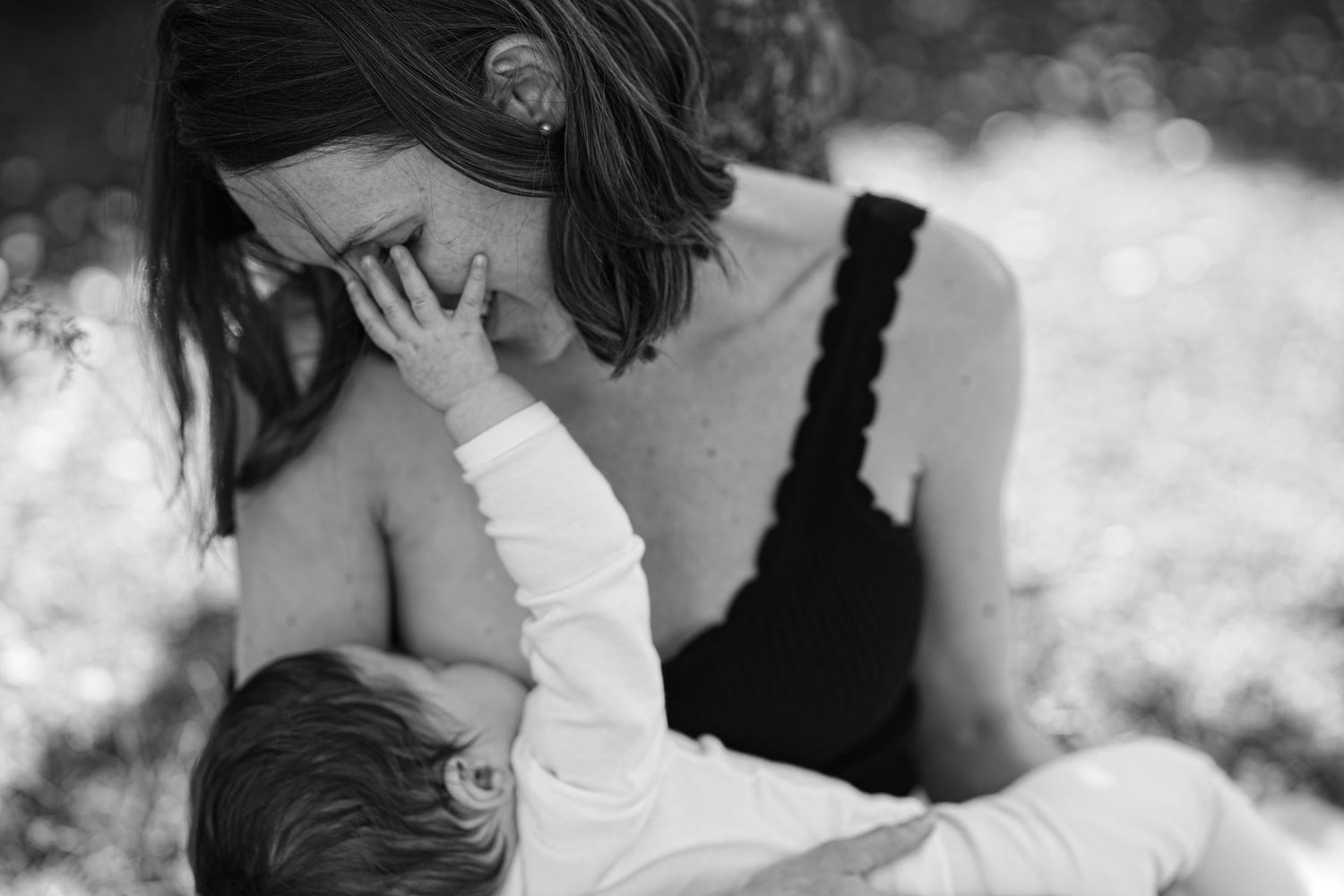 Intimate black and white portrait capturing tender moment between two figures.