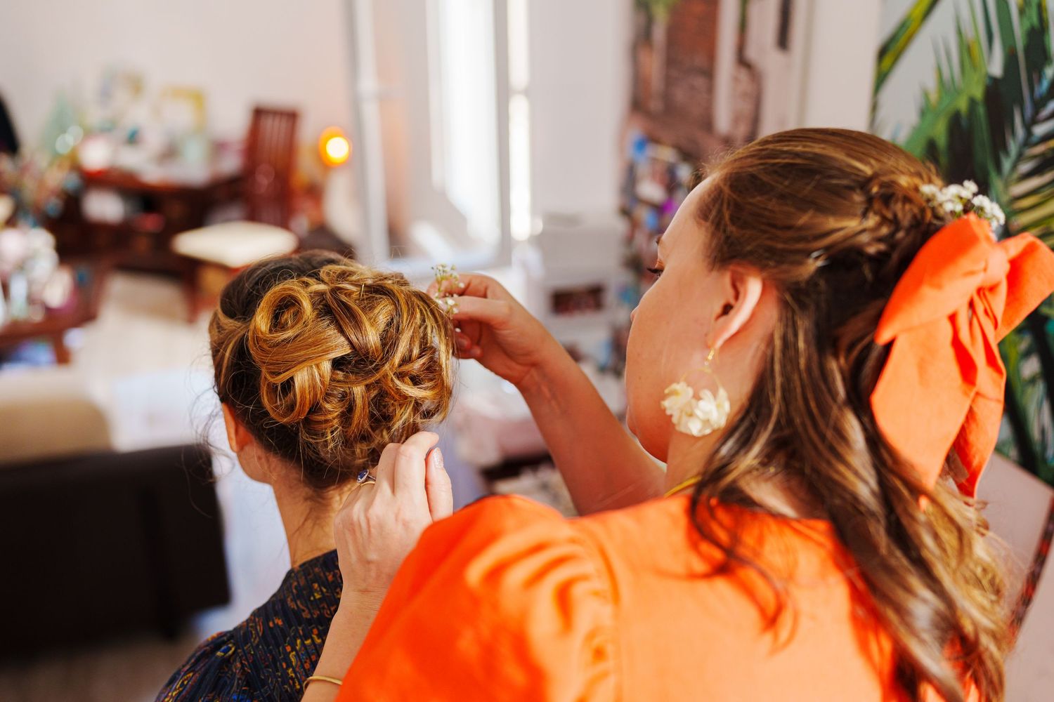 Hair stylist works on an elegant updo hairstyle with decorative pins for a special occasion.