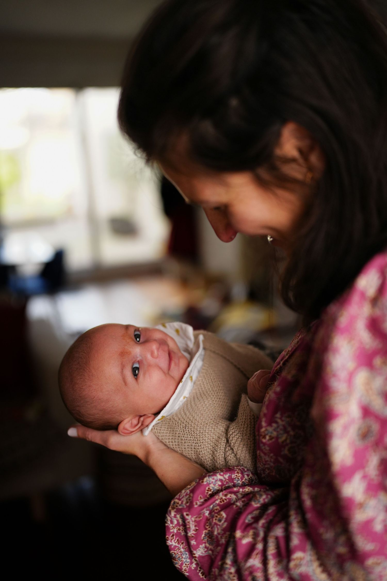Intimate indoor portrait of tender caregiving moment in soft natural light.