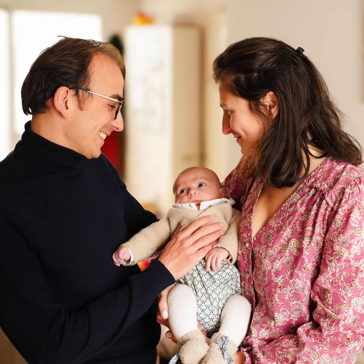 Candid moments of parents interacting with their baby in natural light.